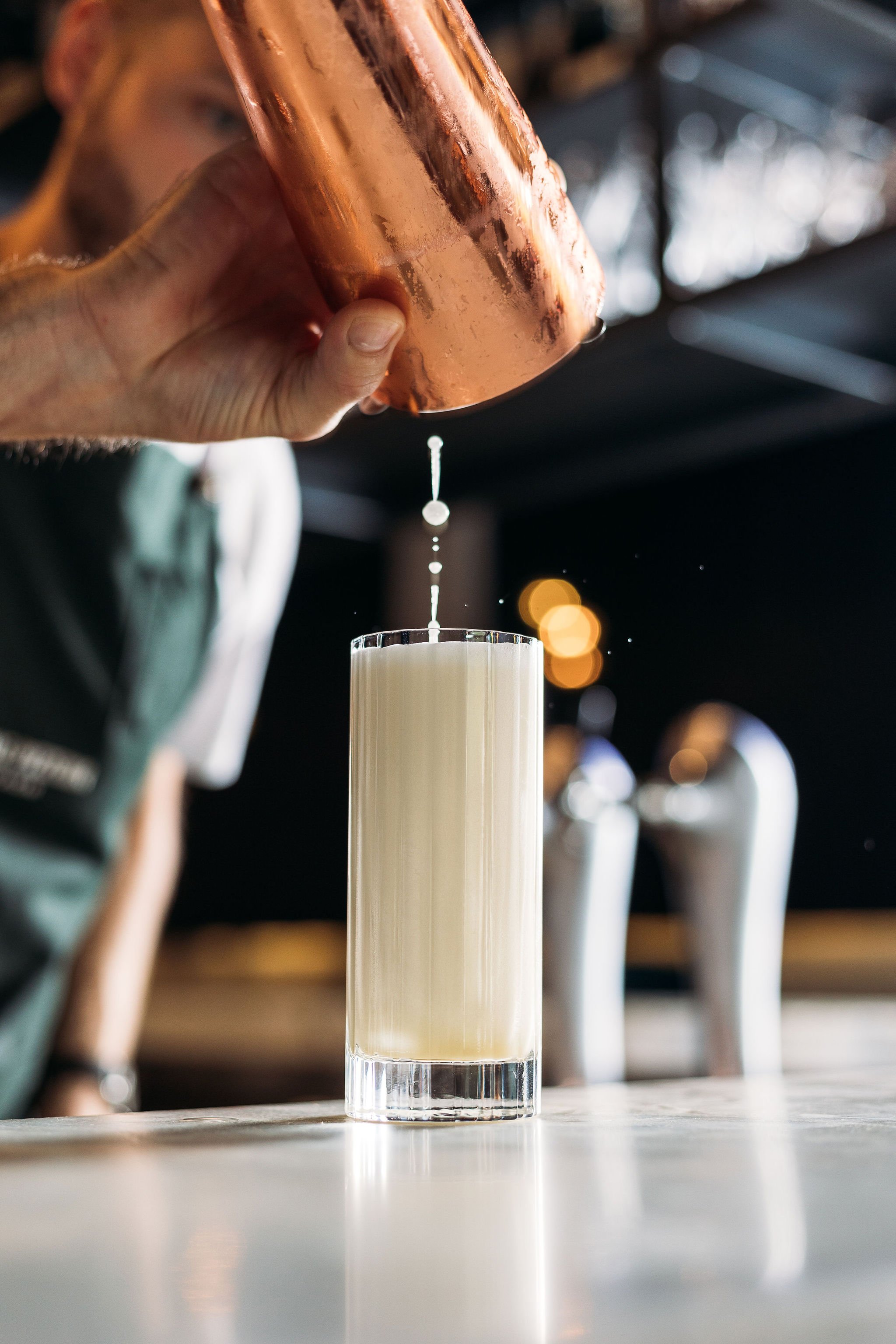Canberra food photographer - bartender pours cocktail