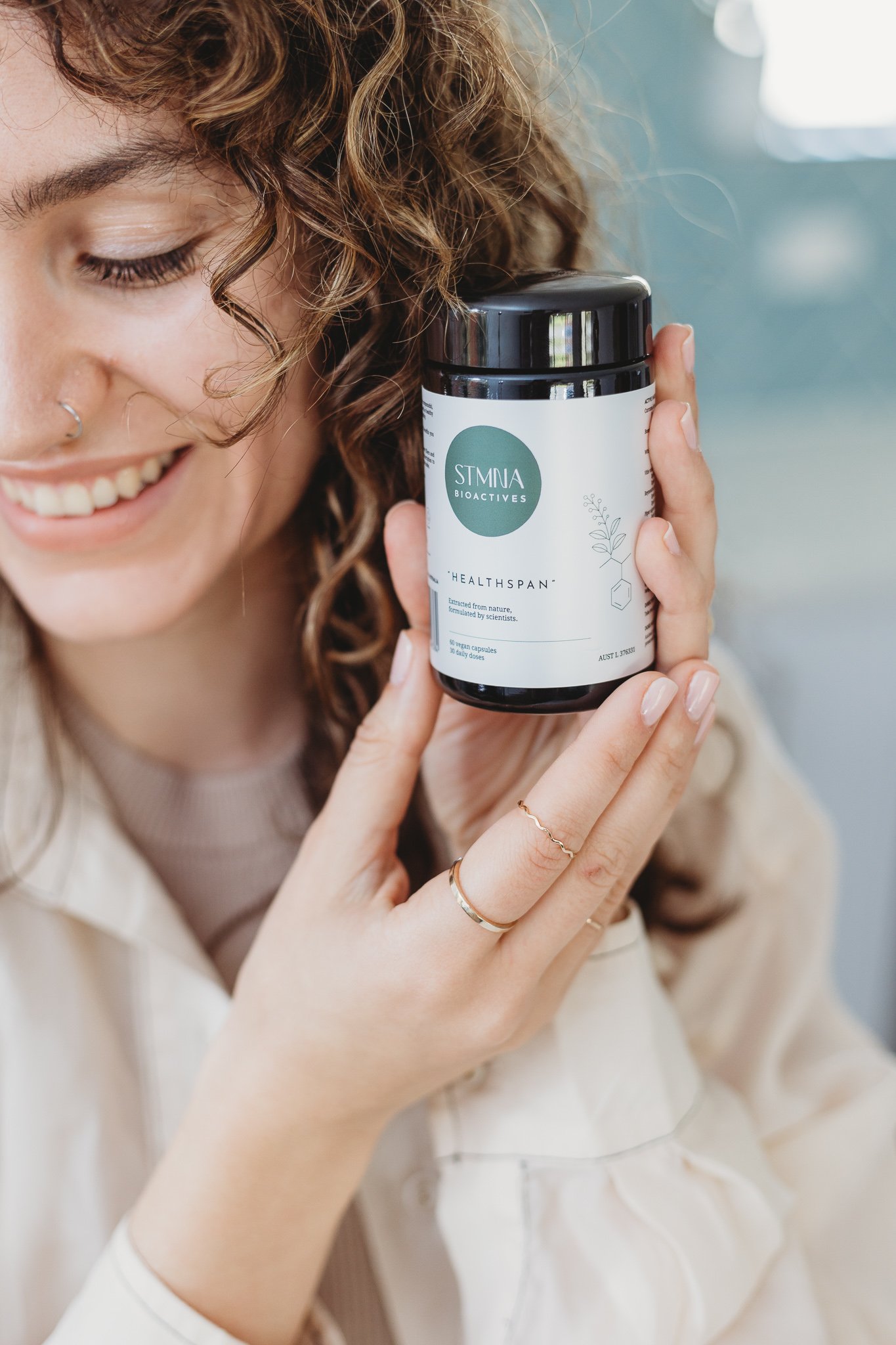 Canberra product photographer - smiling woman holds vitamins