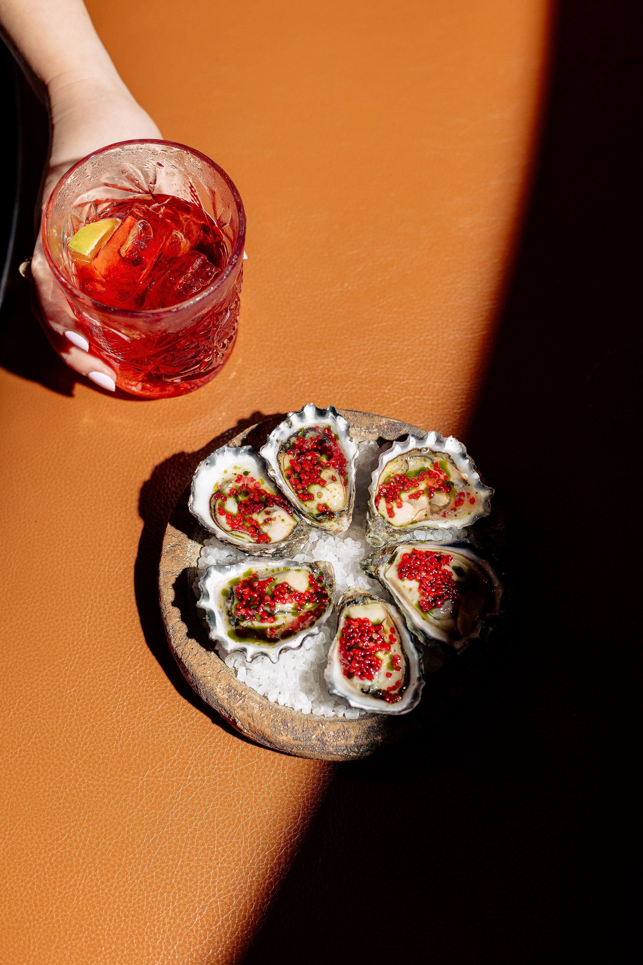 Oysters and cocktail on brown surface - food photography