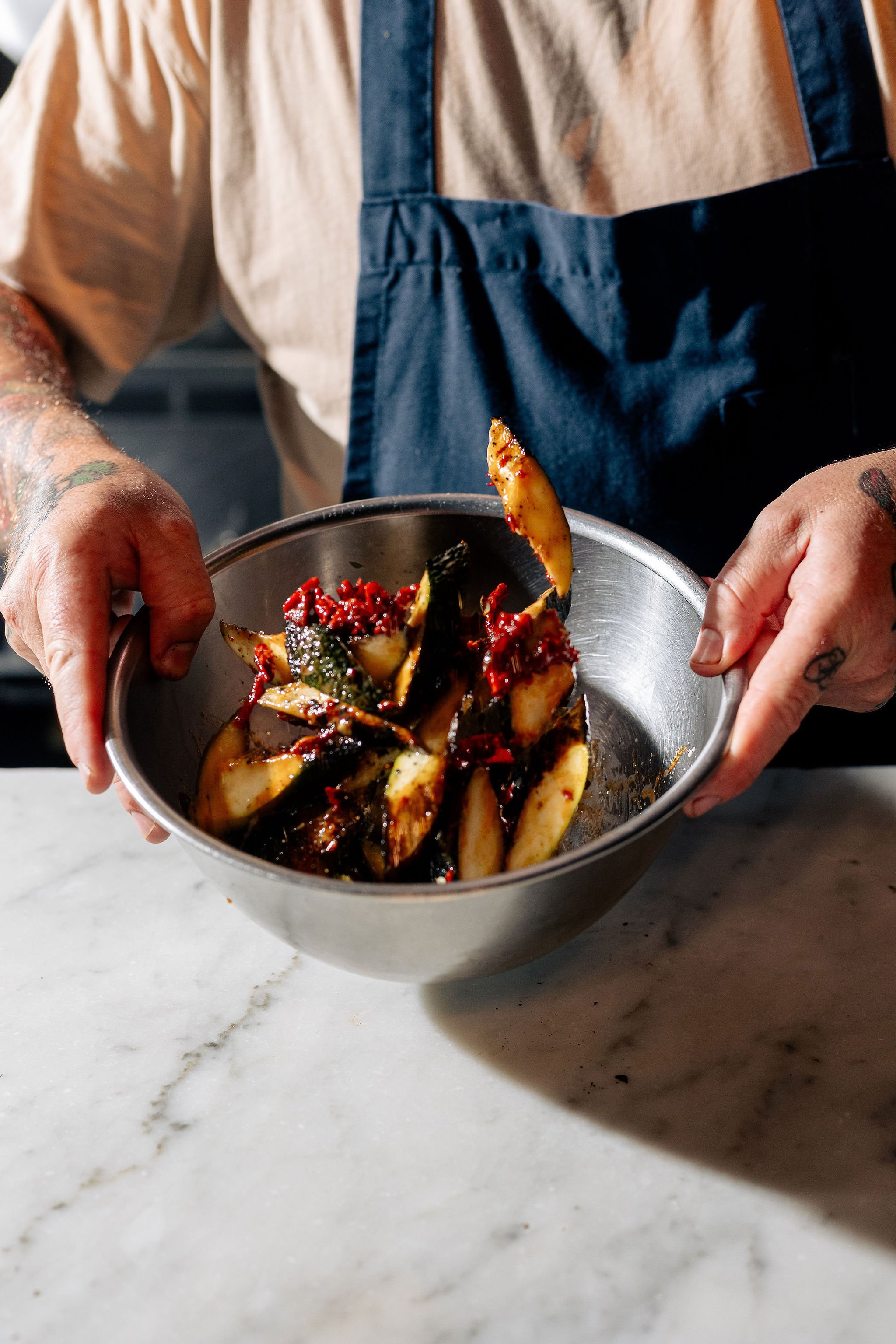 Chef tosses vegetables in bowl - food photographer Canberra