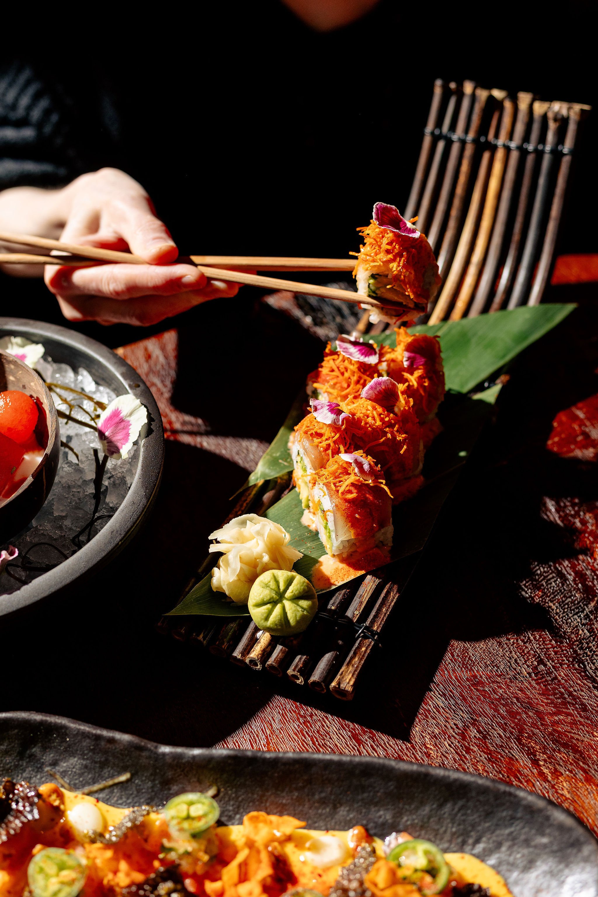 Hands with chopsticks lift sashimi - Canberra food photography