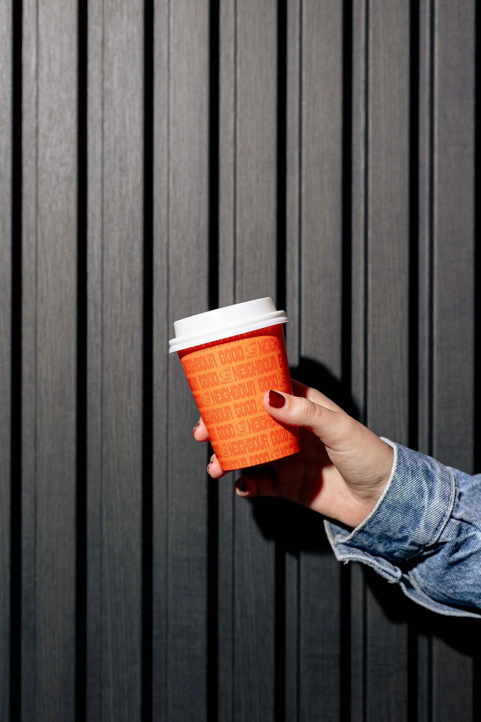 Canberra food photographer - hand holds orange coffee cup