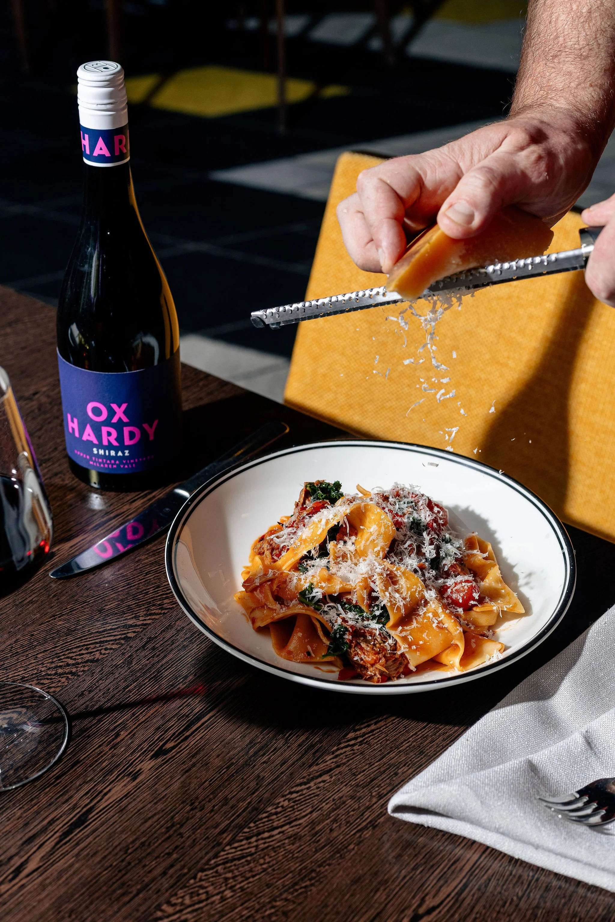 Canberra food photographer - chefs grates cheese over pasta