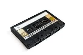 Audio cassette tape with black casing and label, featuring two spools of magnetic tape inside.