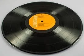 A vintage black vinyl record with an orange label in the center.