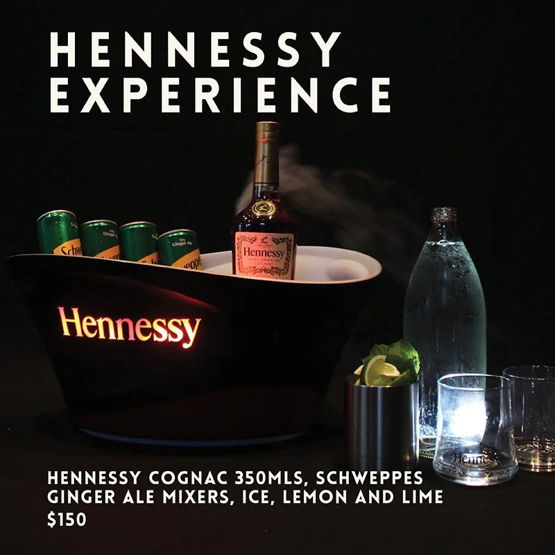 Hennessy bottle and mixers displayed with glasses and lime
