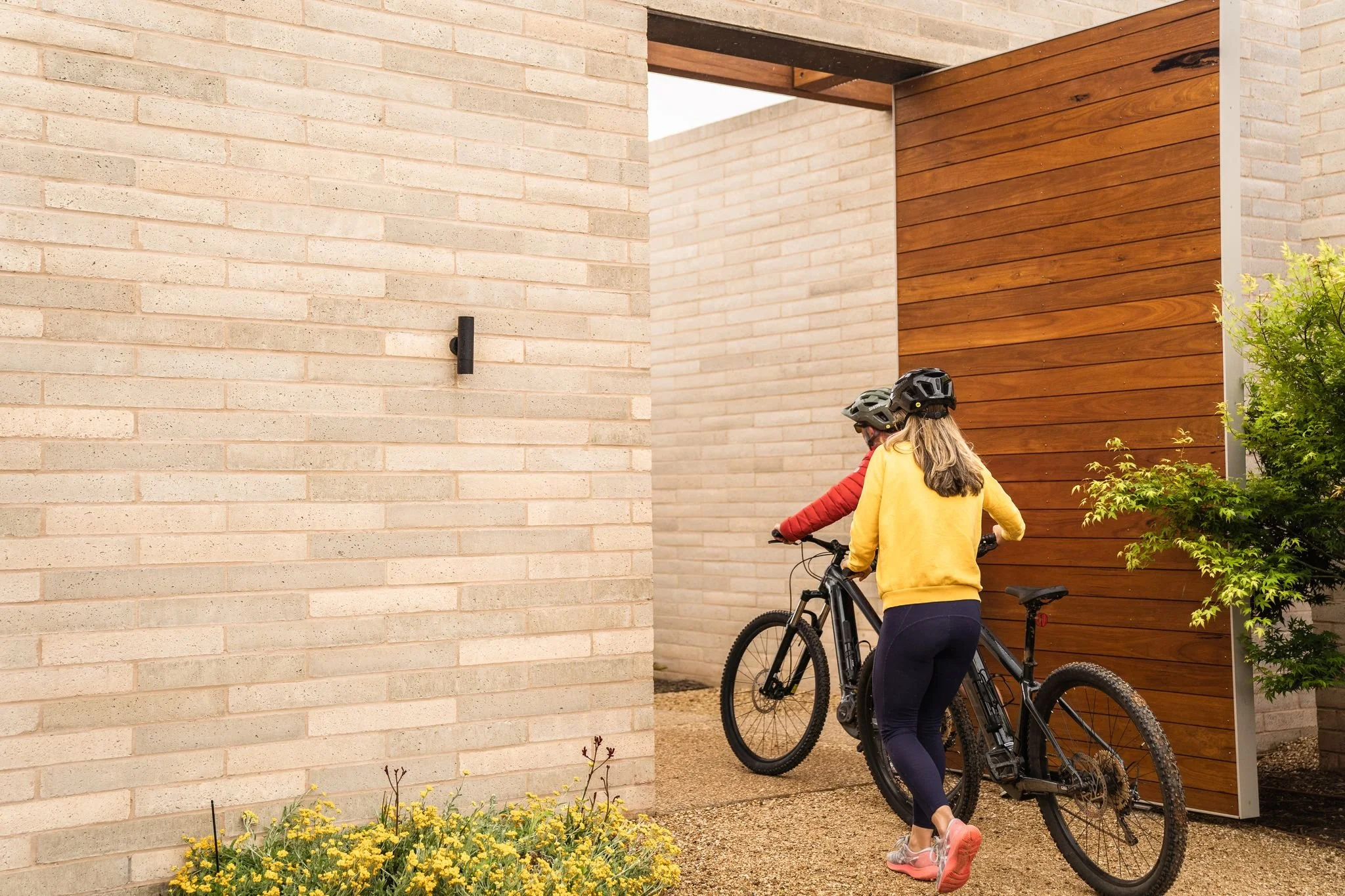 Scenic view of snow-capped mountains in the background with rolling green hills and a modern building in the foreground.