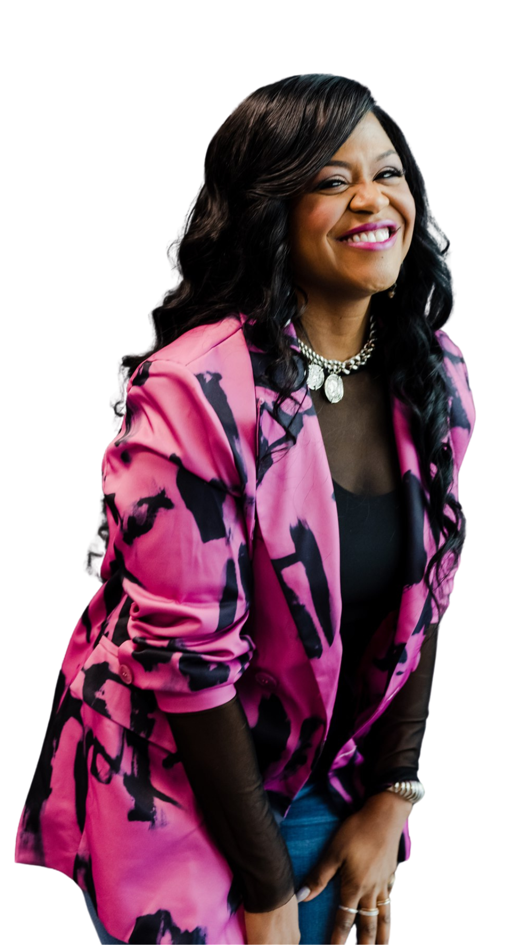Monique Bryan wearing a pink and black patterned blazer, black top, and statement necklace.