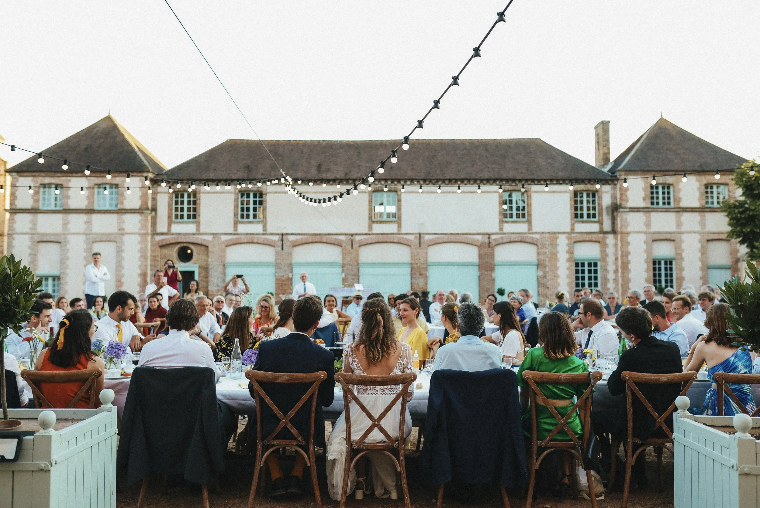Outdoor château wedding reception in the historic courtyard at Château des Joncherets near Paris, France.