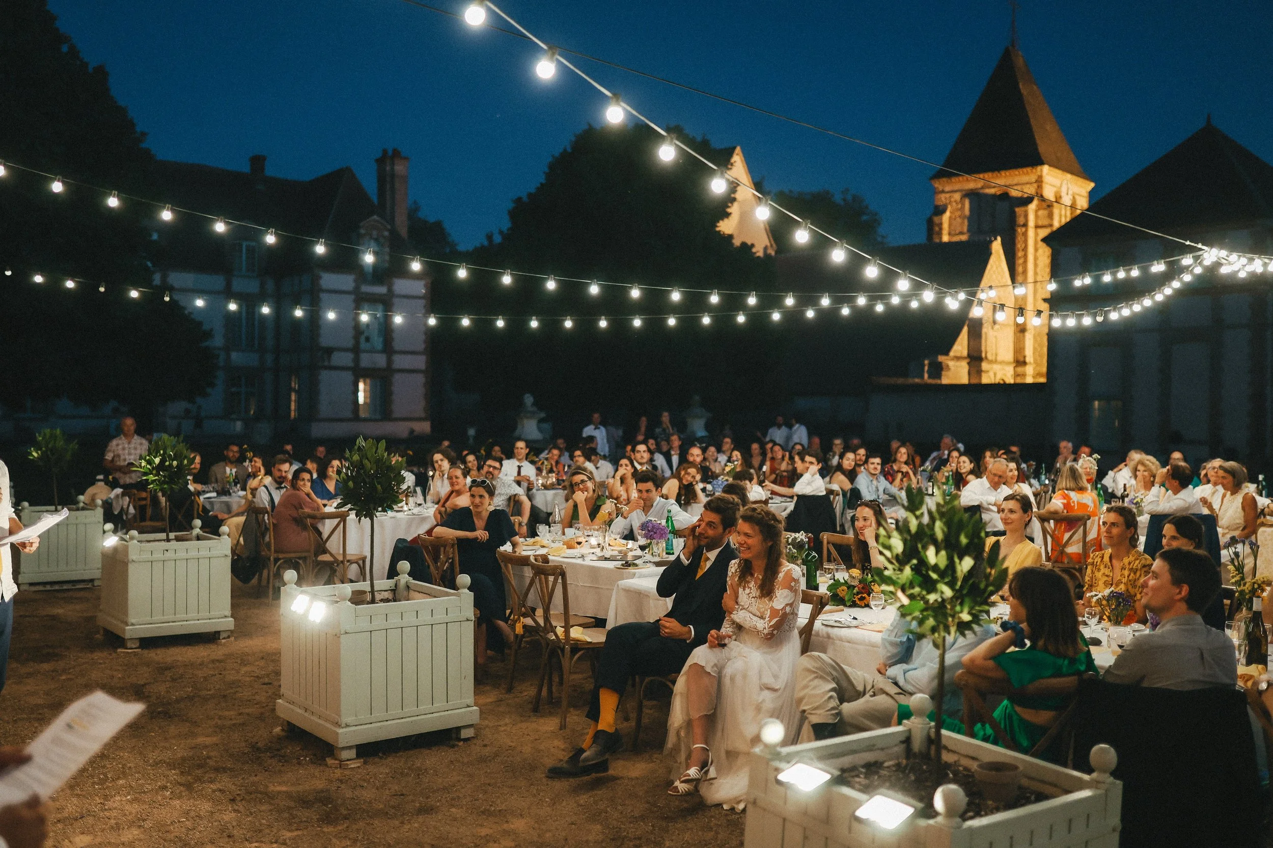 Outdoor château wedding reception in the historic courtyard at Château des Joncherets near Paris, France.