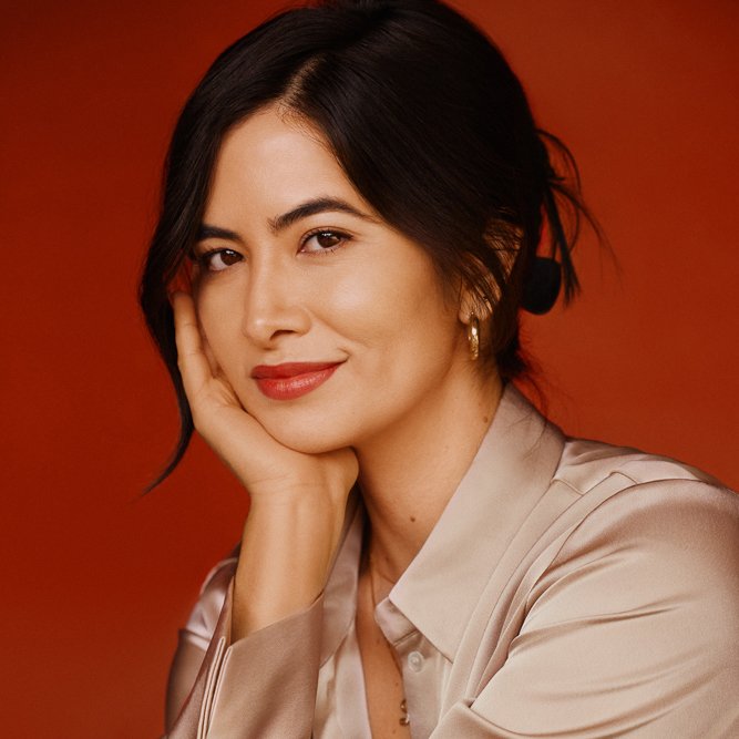 Circle shaped portrait of Lwany, a petite fashion expert on a red background.
