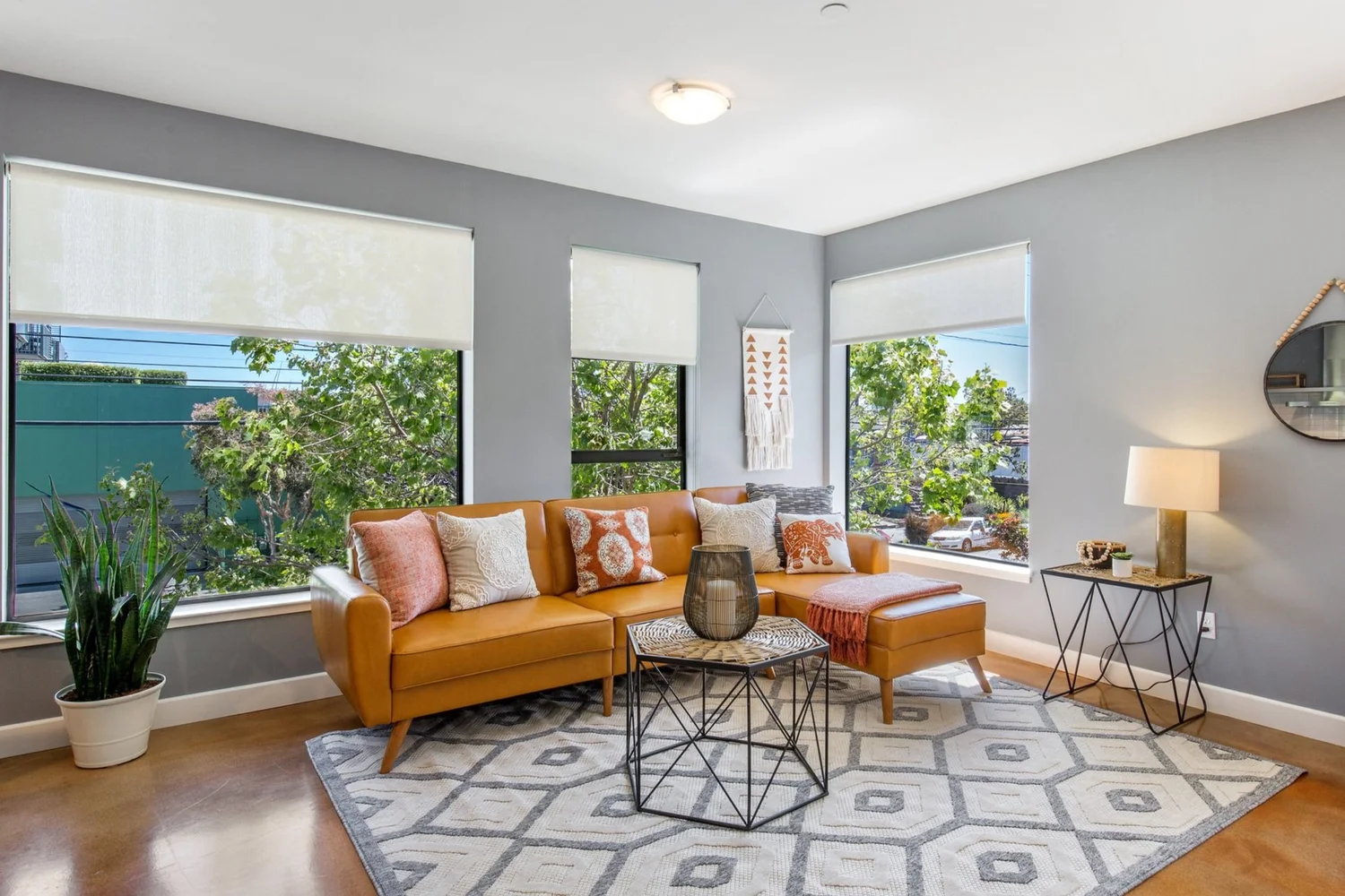 Light-filled living room with an orange sofa, tall windows and an open, flexible layout