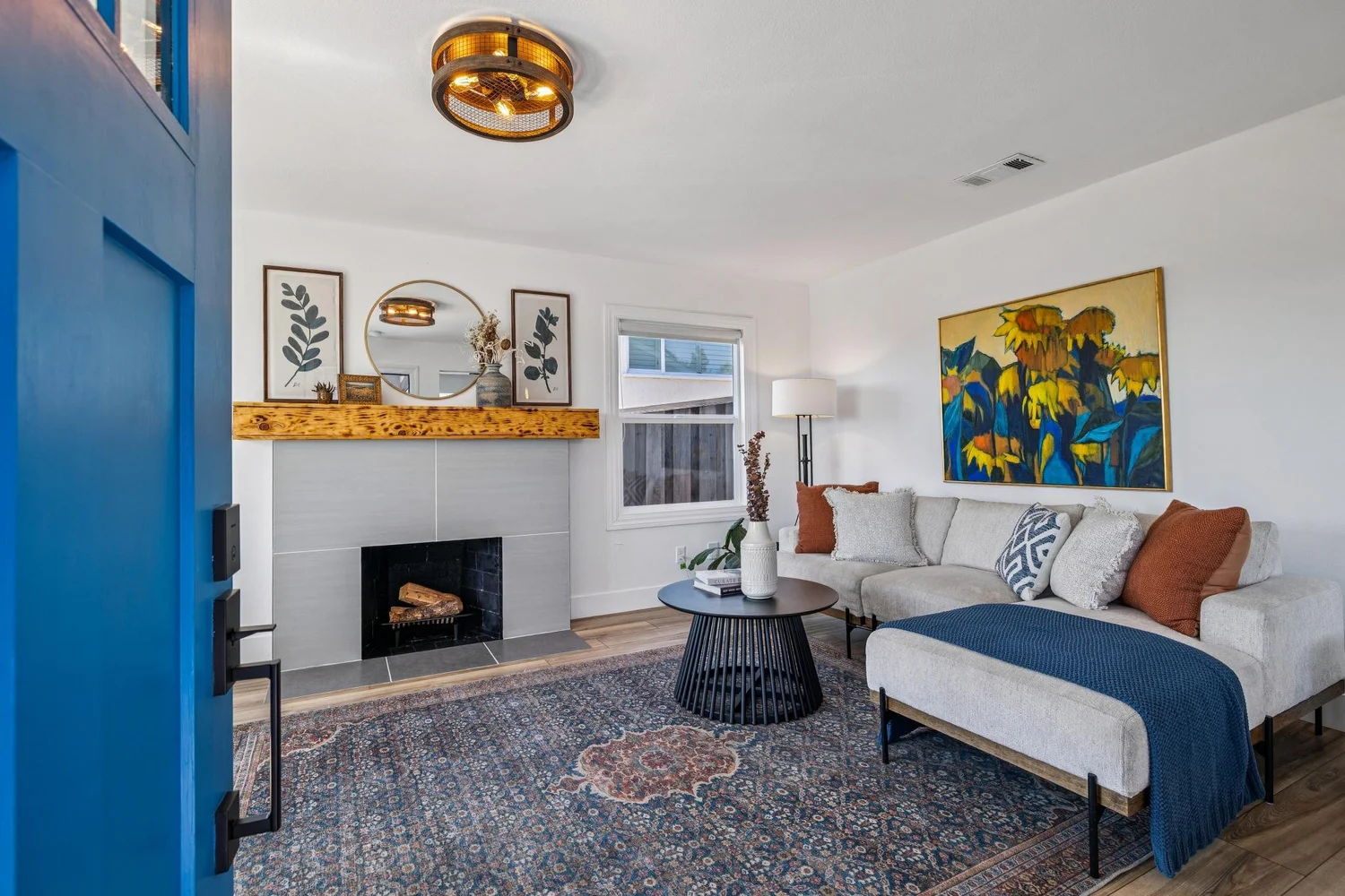 Thoughtfully presented living room with a fireplace, warm wood mantel, artwork and a welcoming seating area