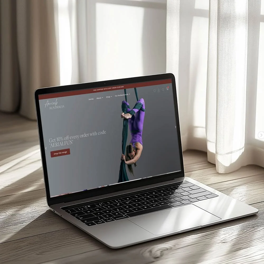 Aerials Australia website shown on a laptop placed on a wooden floor, designed by Queensland Wordpress website designer Luda Creative