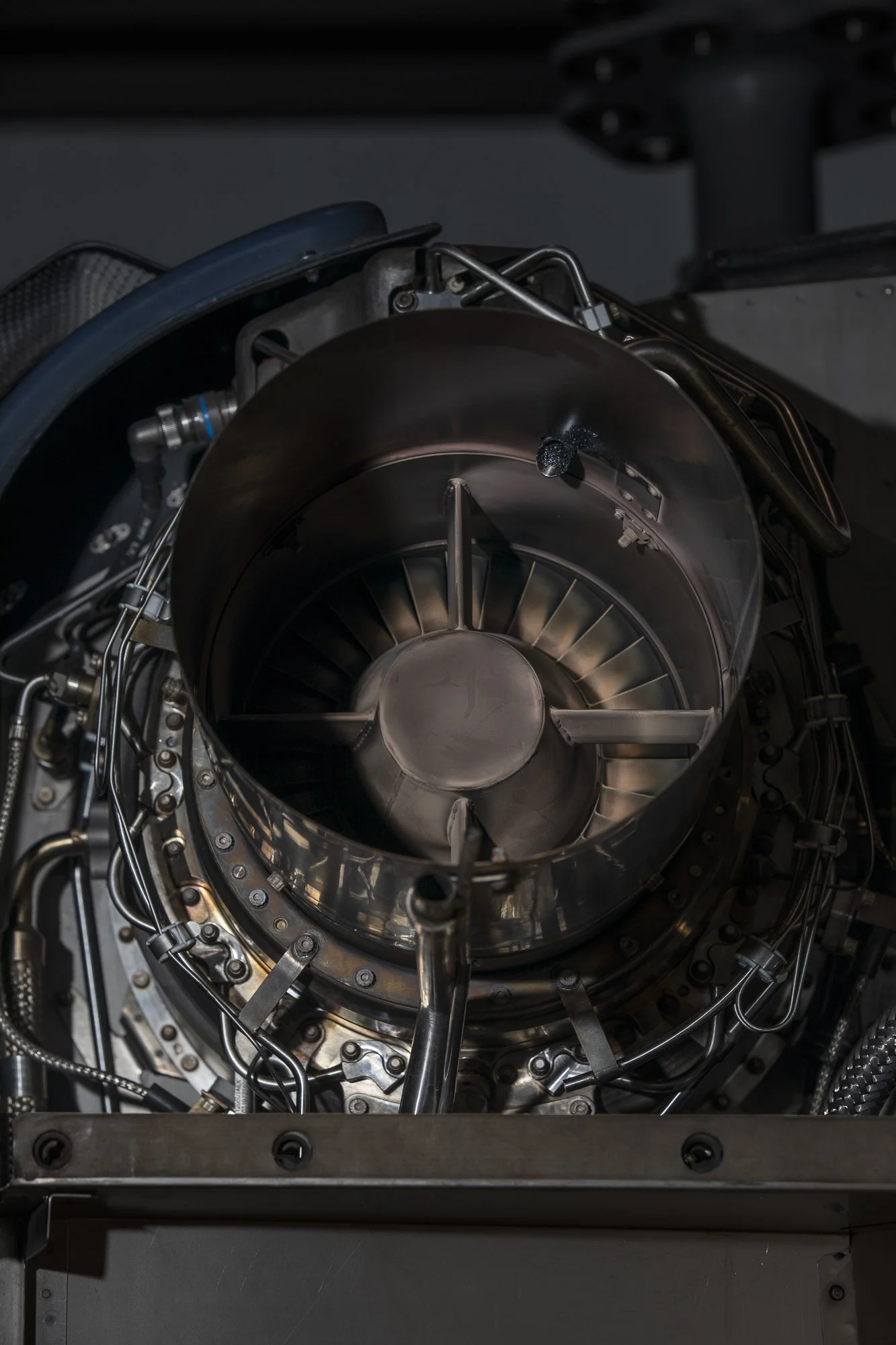 Vue d'un réacteur d'avion ou moteur de fusée, avec de nombreux composants métalliques et câbles.