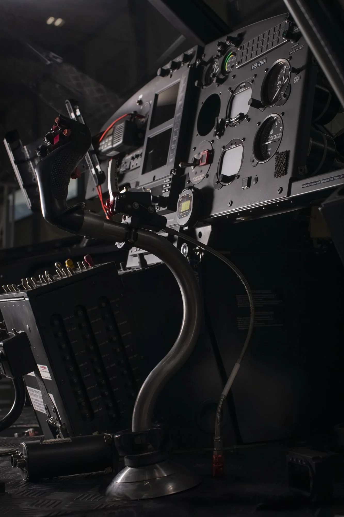Poste de pilotage d'un avion avec des instruments et commandes, y compris une manette de contrôle et des écrans électroniques.