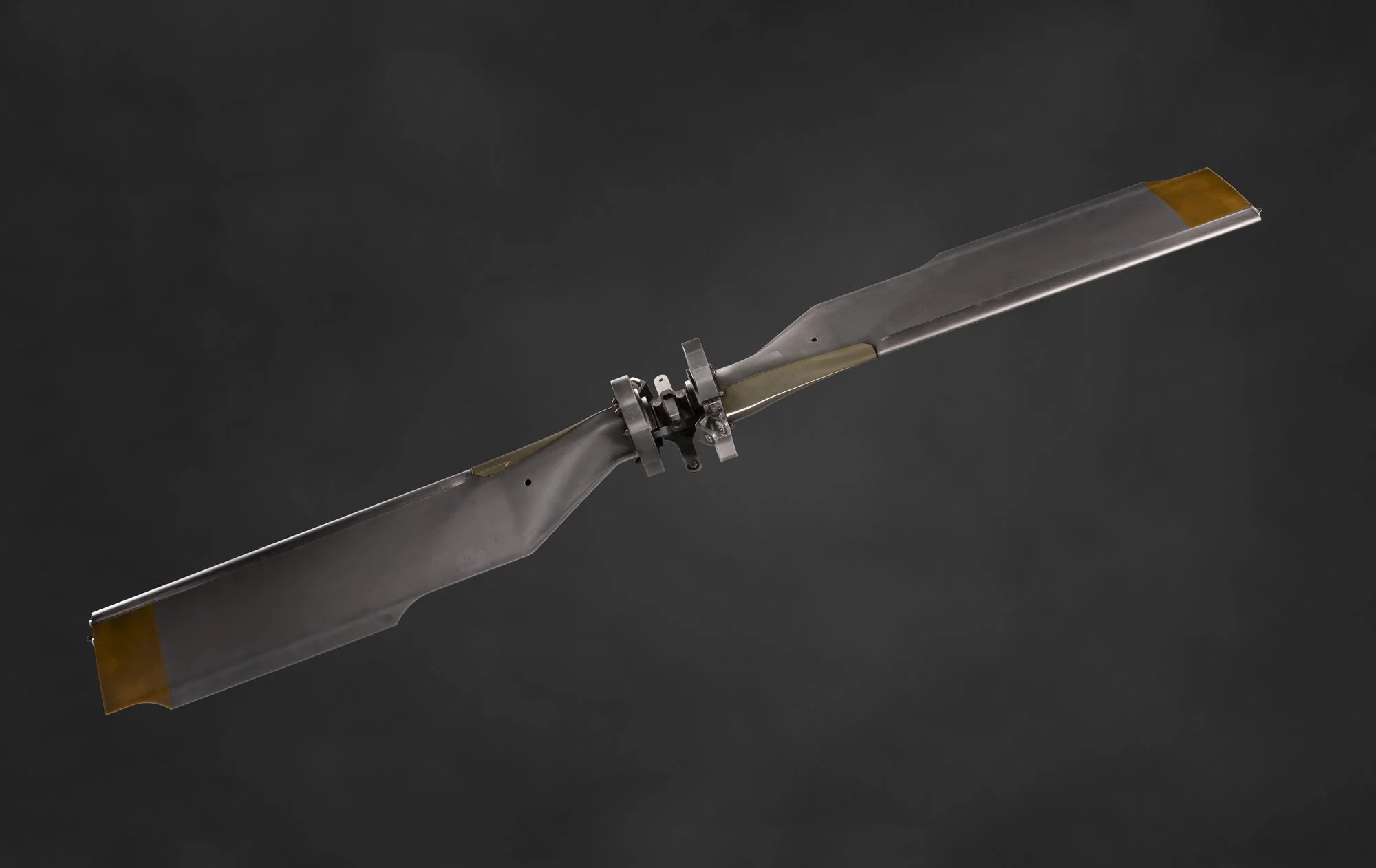 Une pâle d'hélicoptère suspendue dans le vide contre un fond noir.