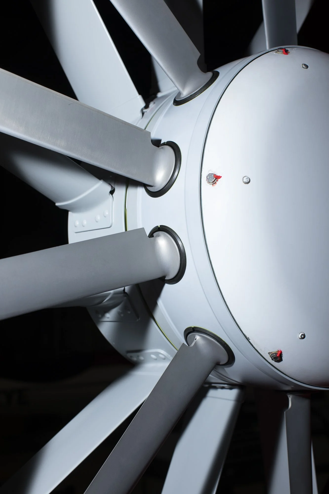 Vue rapprochée d'une partie d'une machine ou d'un robot avec des bras en métal gris et une structure blanche ronde.