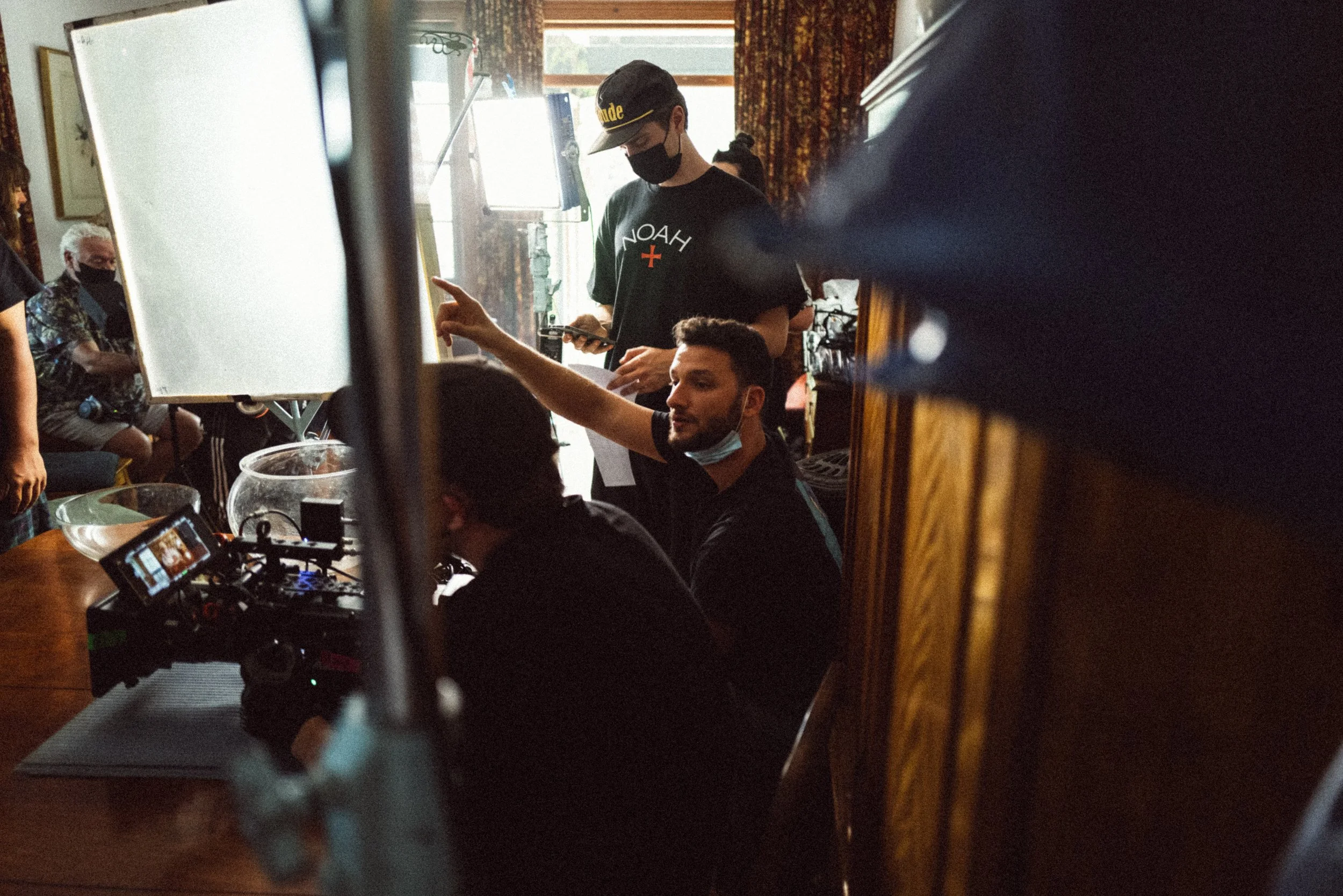 Film crew setting up equipment in a room, with lights and camera on a table.