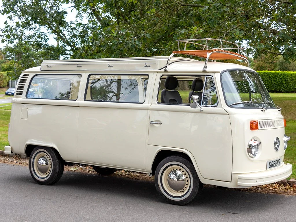 A vintage cream-colored Volkswagen camper van hearse