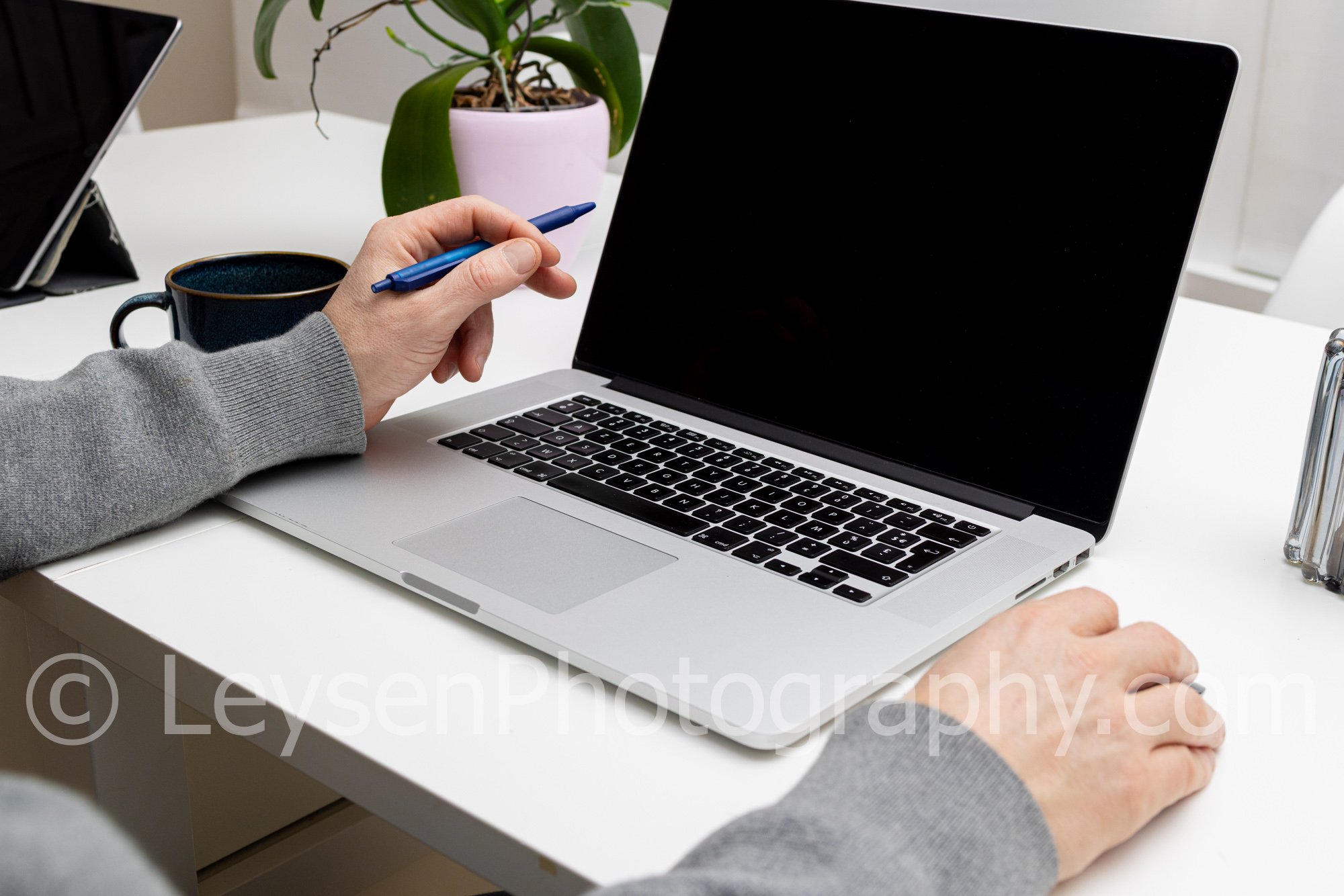 Person Working on Laptop with Pen – Modern Workspace Stock Photo