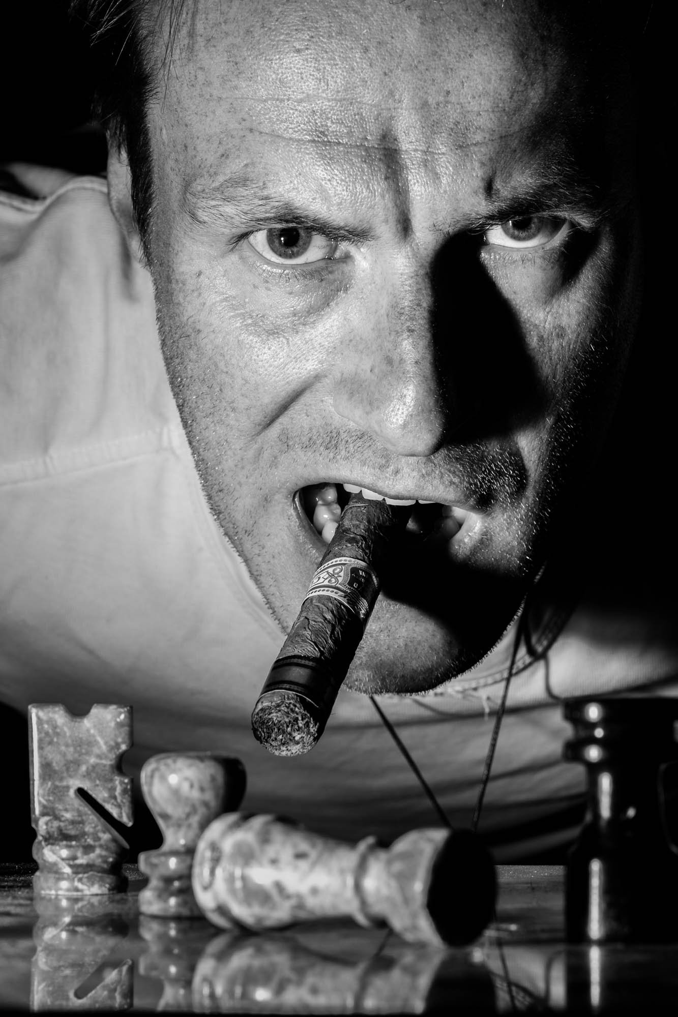 "Zwart-wit portret van Olivier Leysen, professioneel fotograaf uit België, met een zelfverzekerde blik en dynamische belichting – gespecialiseerd in portret-, product- en huwelijksfotografie."