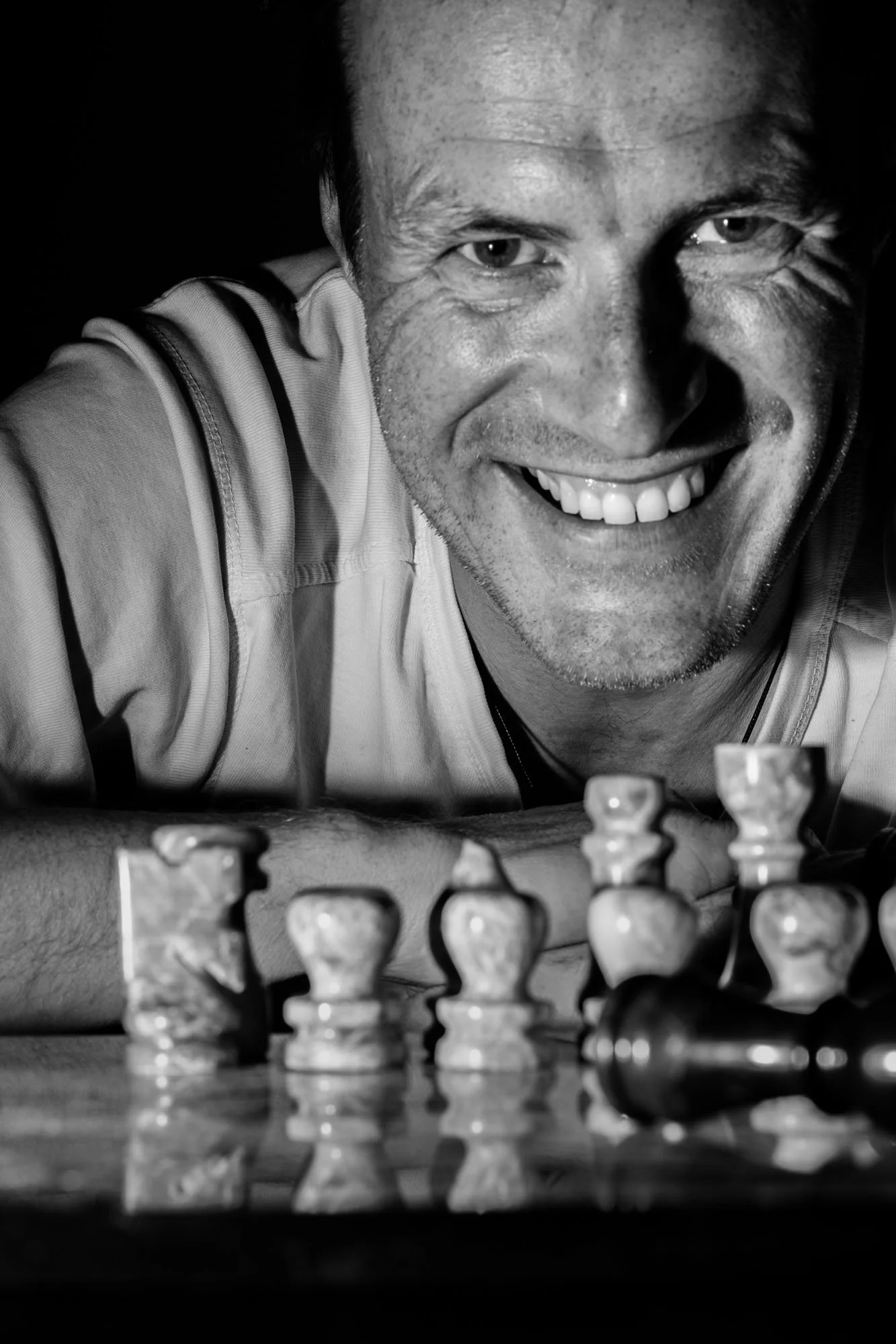 Fotograaf Olivier Leysen houdt een camera omhoog tegen een minimalistische achtergrond – gespecialiseerd in portret-, product- en vastgoedfotografie.