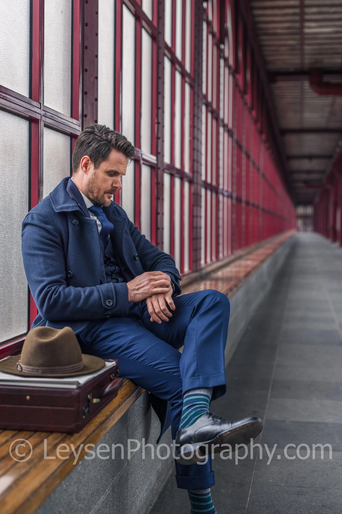Businessman checking time while sitting at train station