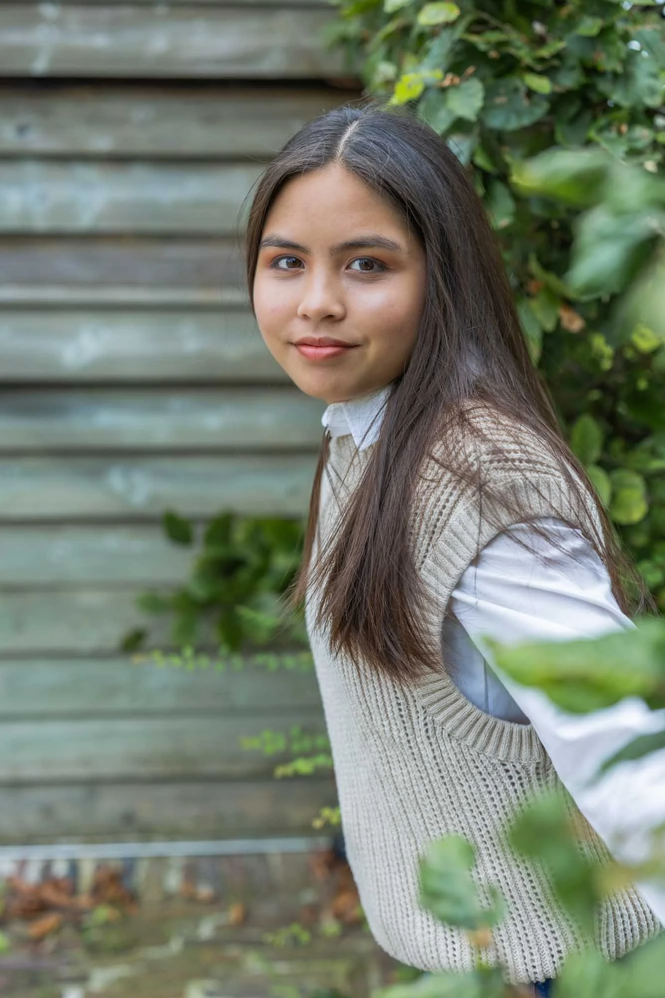 Portret Mechelen – vrouw poseert spontaan in tuin, natuurlijke schoonheid met zachte blik en warme sfeer
