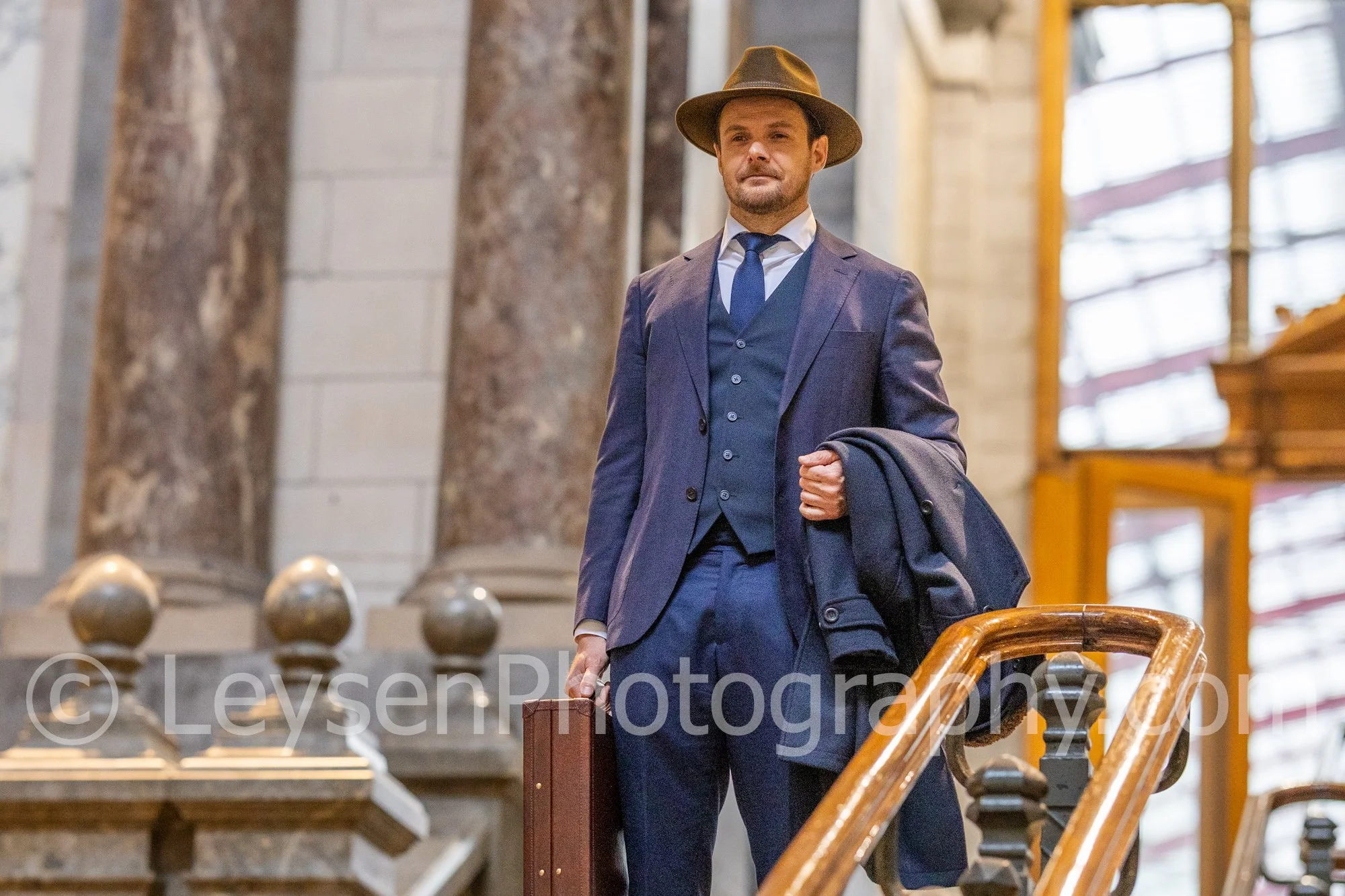 Confident Businessman Standing on Stairs with Coat and Briefcase