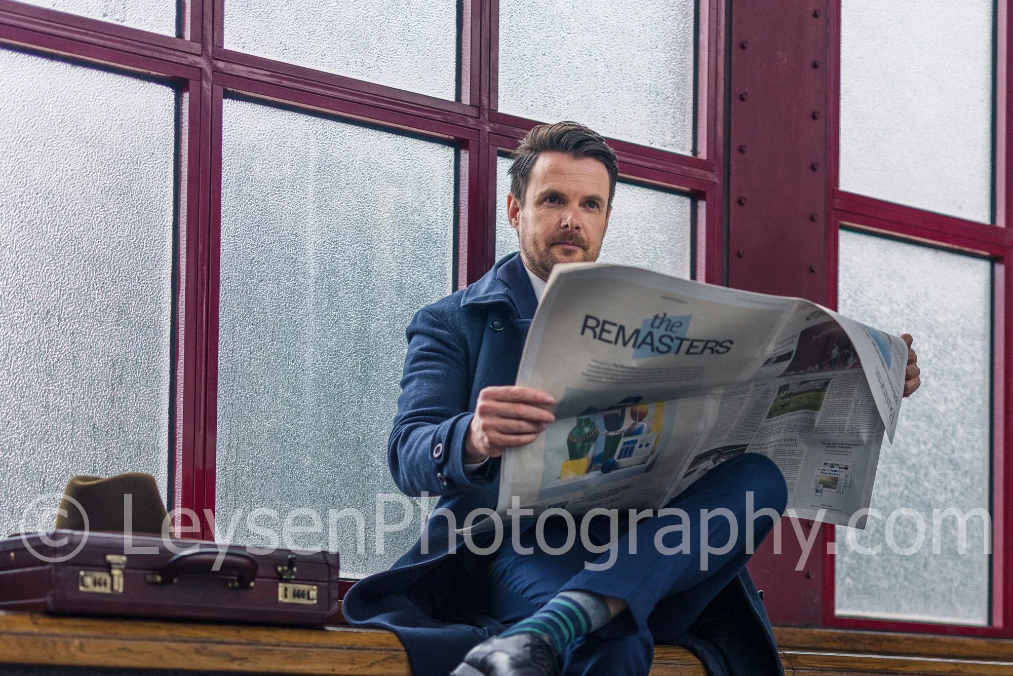 Businessman reading newspaper in modern urban station