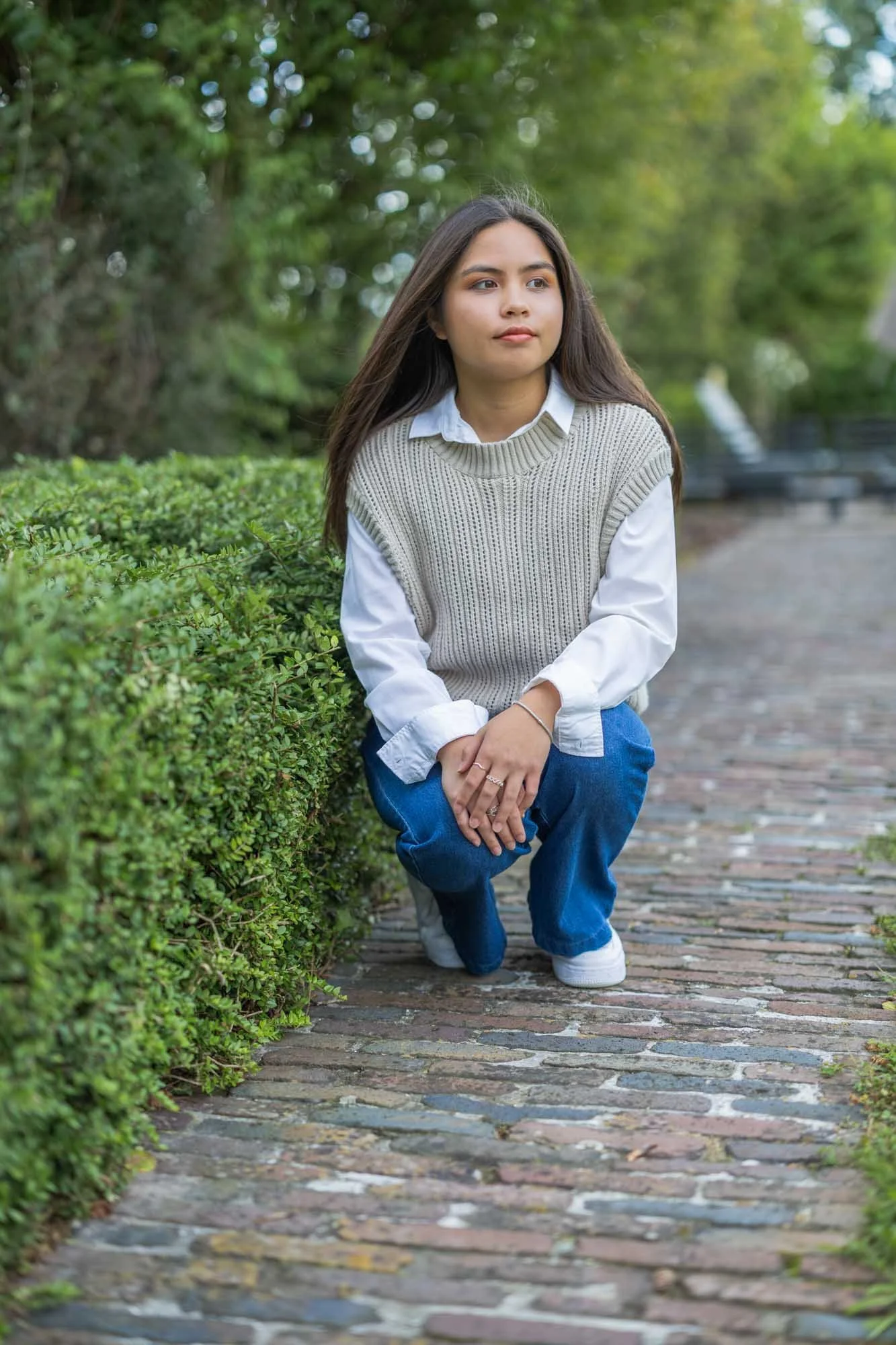Portretshoot Mechelen – vrouw zittend op kasseipad in tuin, rust en zachtheid centraal, gefotografeerd door Leysen Photography
