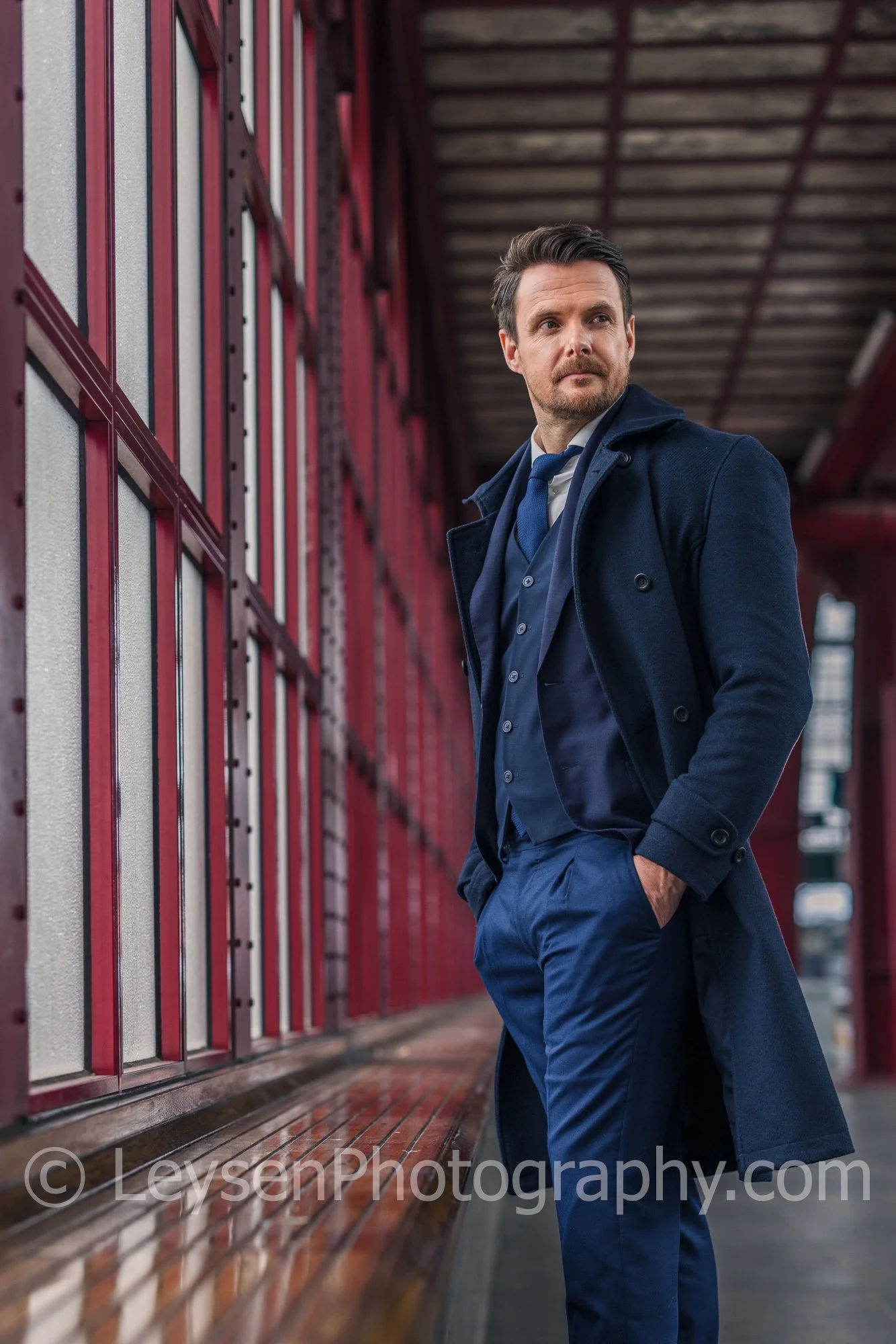 Stylish businessman walking along urban station platform