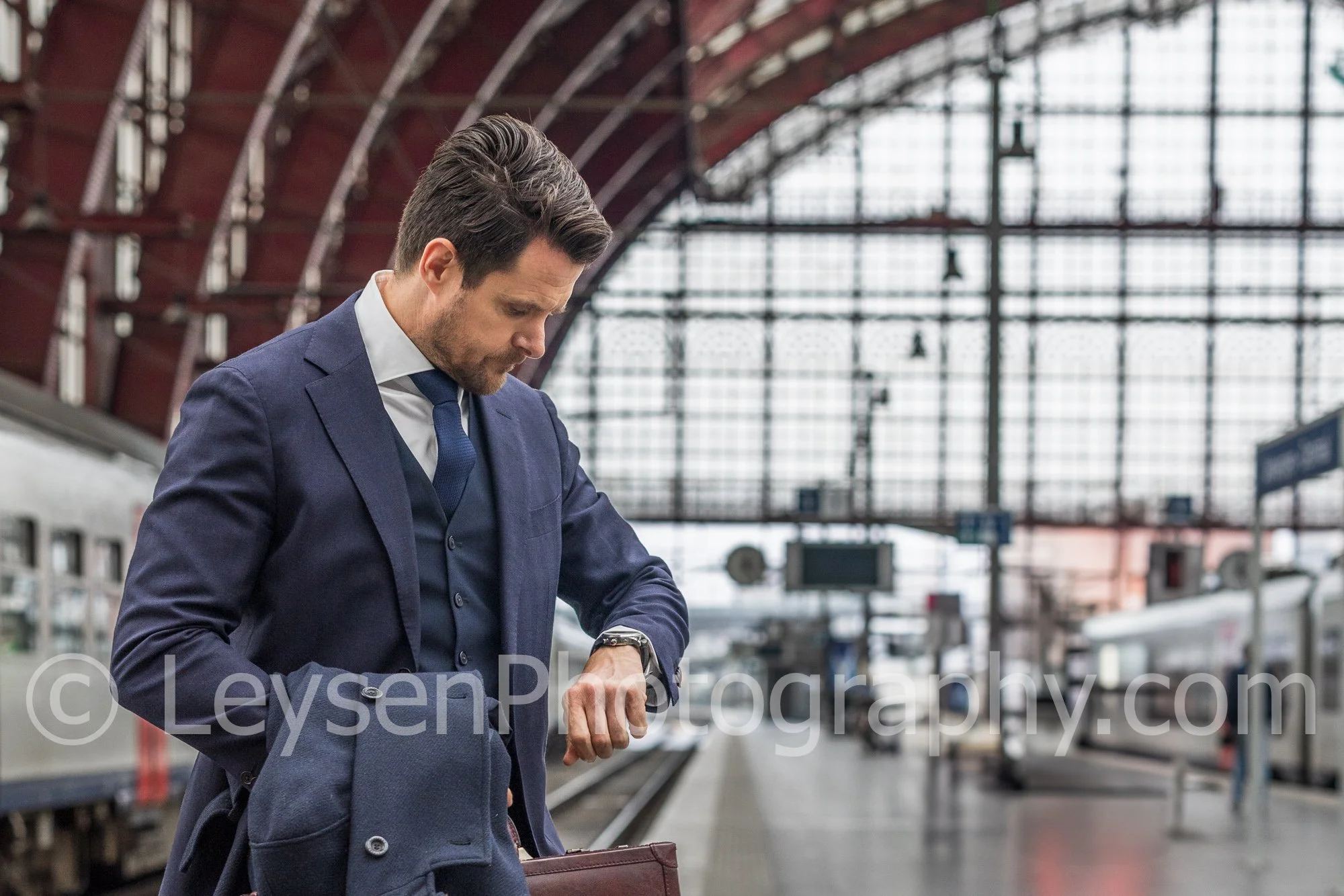 Businessman Checking Watch on Train Platform – Corporate Travel Stock Photo