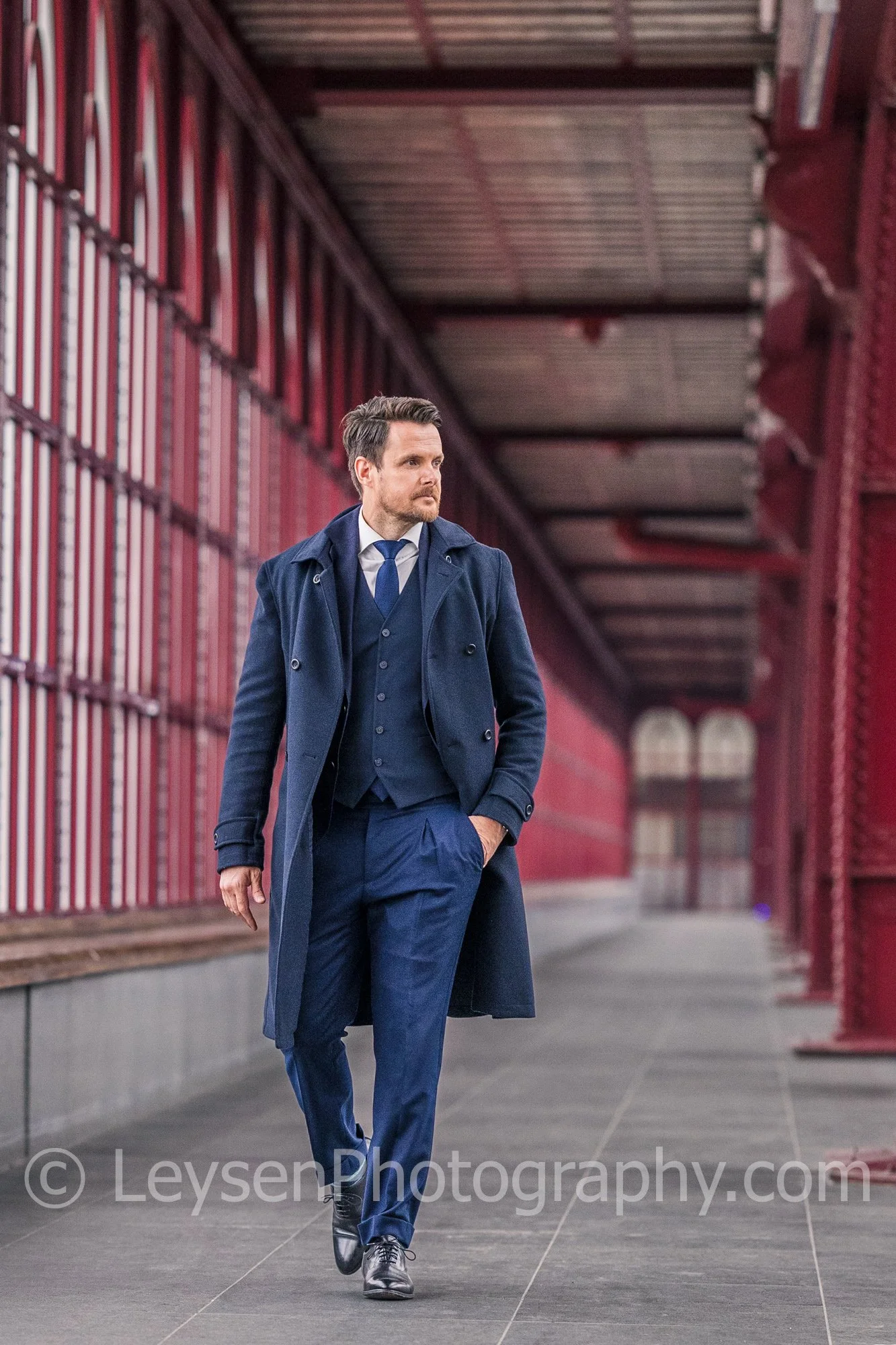 Stylish Businessman Walking in Urban Architectural Corridor