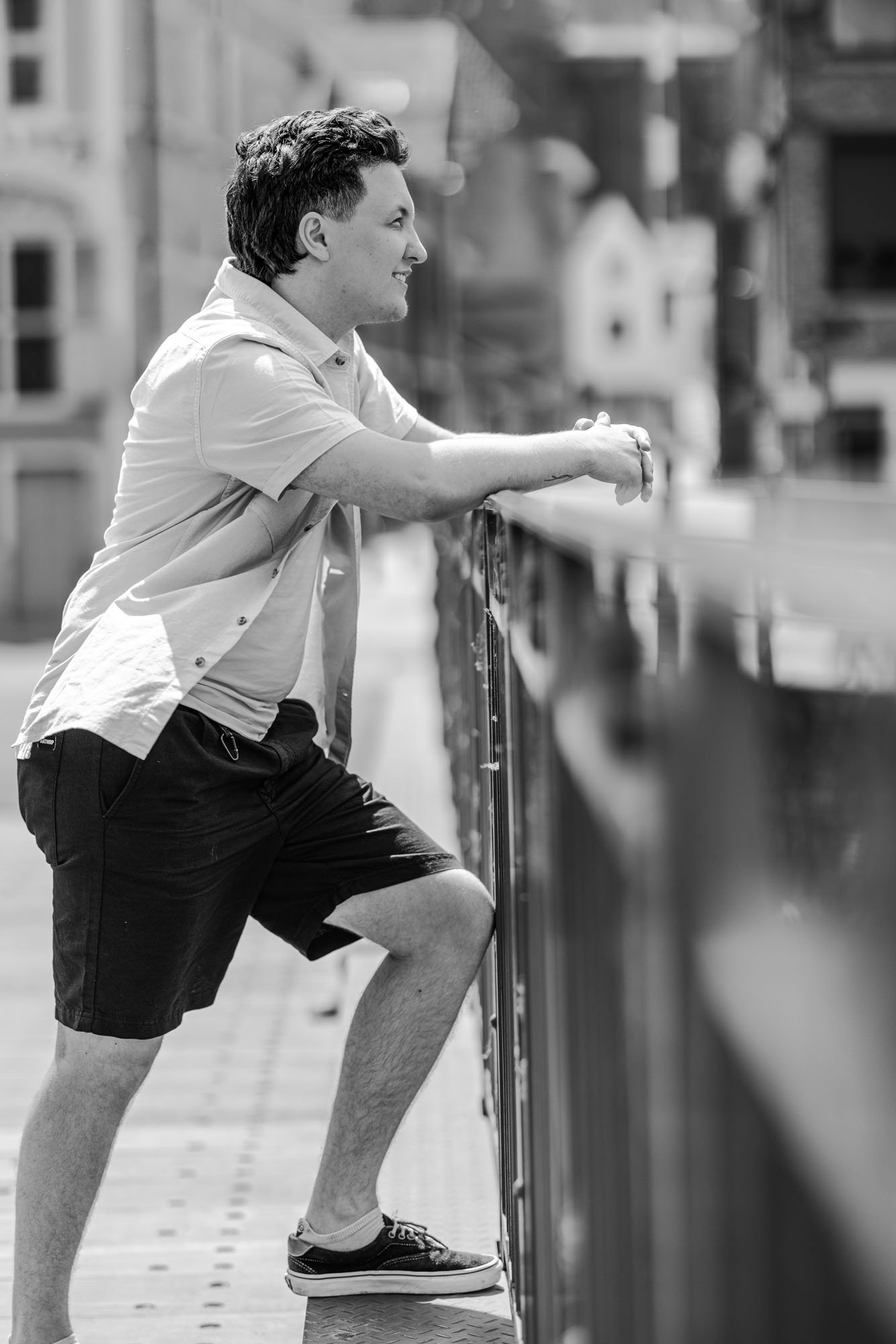 zwart wit lifestyle portret van Alex verspecht, fotograaf Leysen te mechelen. man kijkt voor zich uit naar de boten op de Dijle ter hoogte van een brug,  