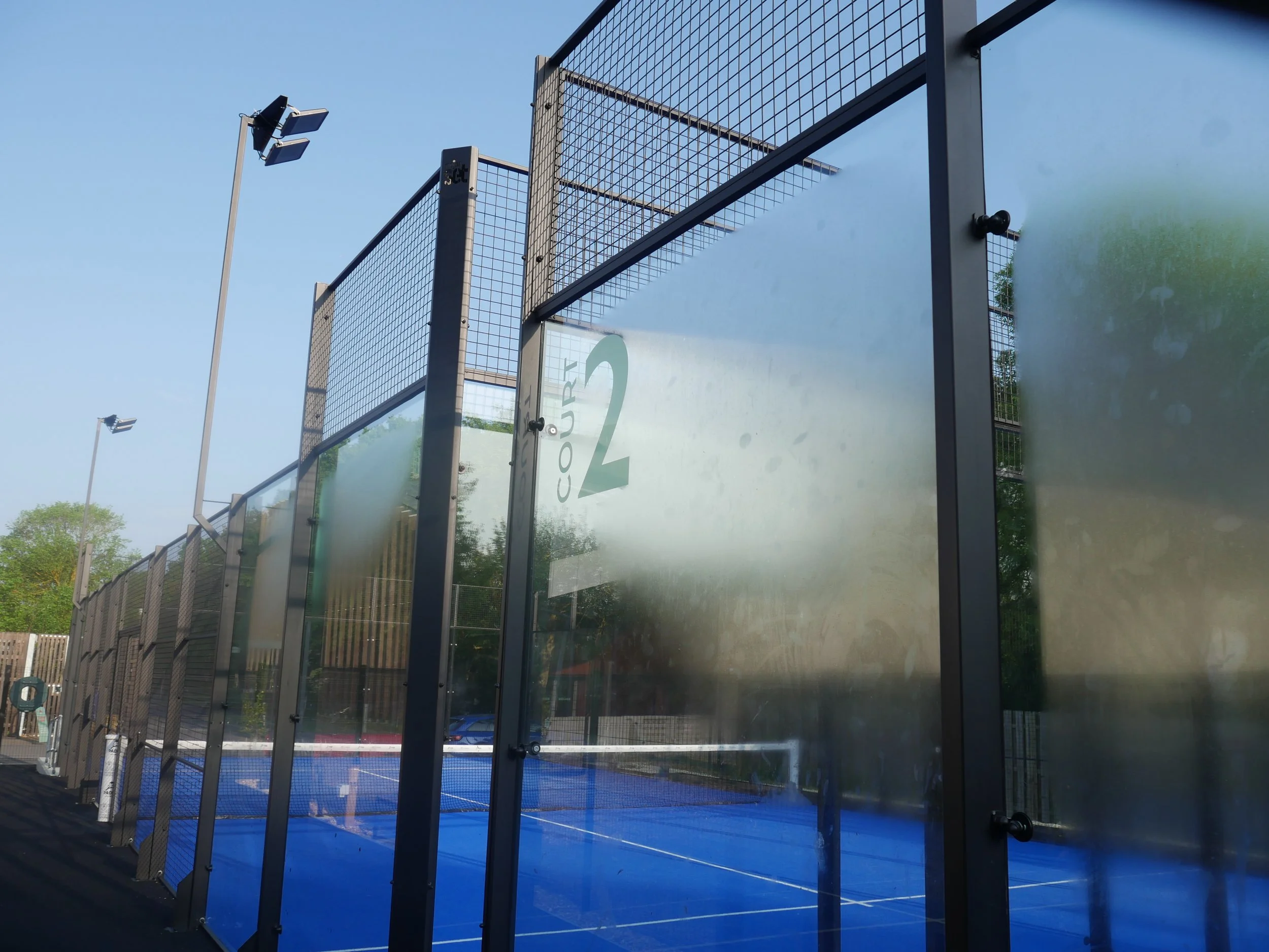 Outdoor padel tennis court with blue surface at the university of cambridge. Best Uk Padel Court Suppliers