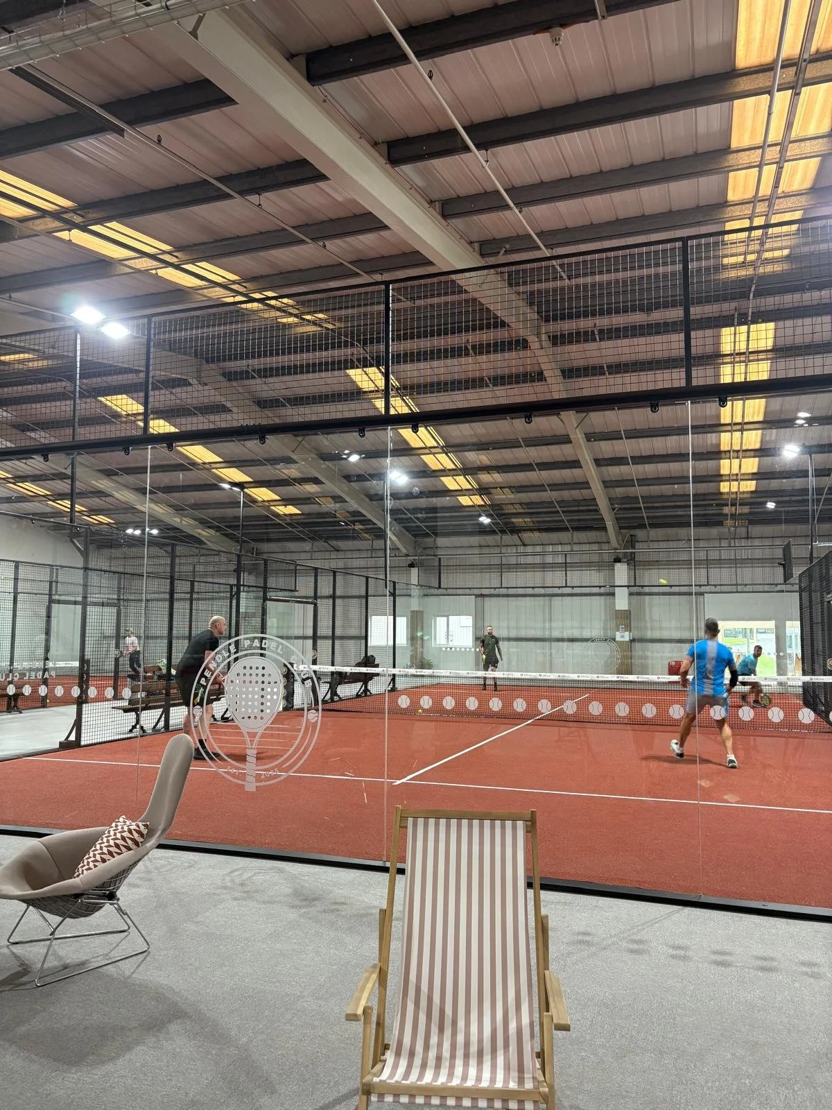 Indoor padel court with players engaged in a game at Pendle Padel Club - Burnley UK.