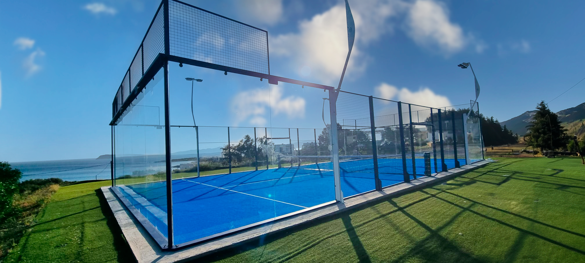 An outdoor FIP Official Padel Court. With a dark blue frame and blue turf.