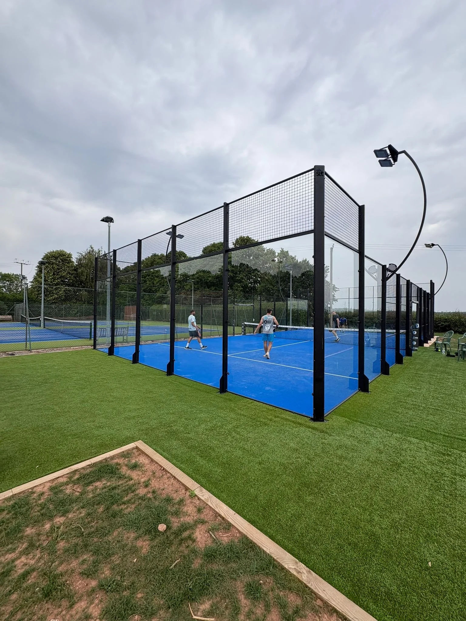 People playing padel tennis on a blue court, UKs Best Padel Courts