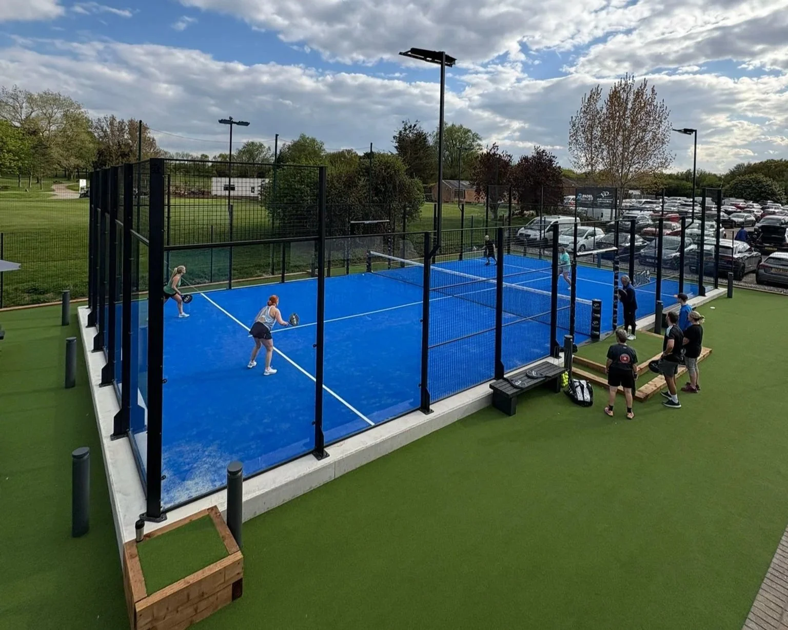 Padel court with players and spectators, in the UK