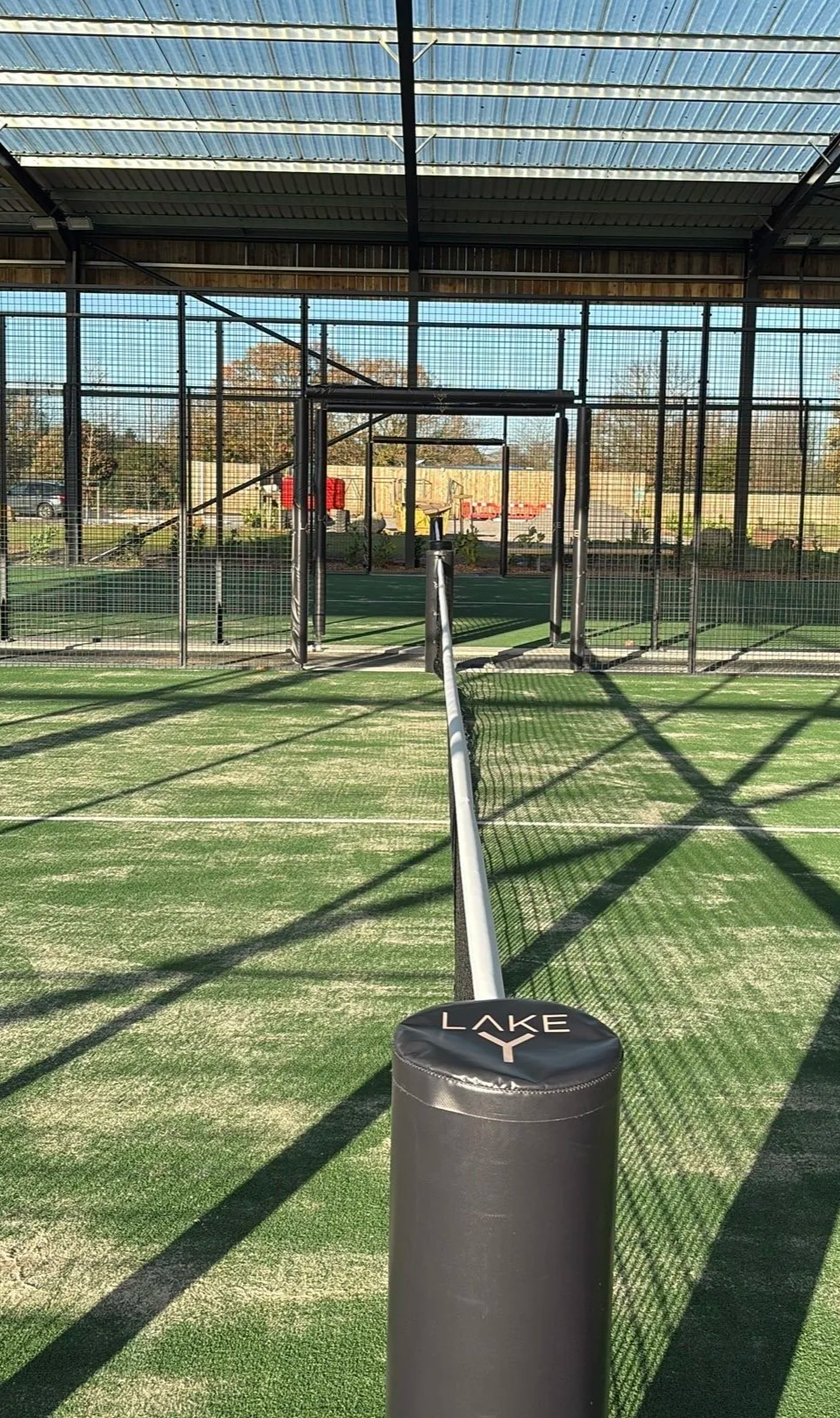 Indoor Padel Court with green turf underneath a canopy at Lake Y, UK
