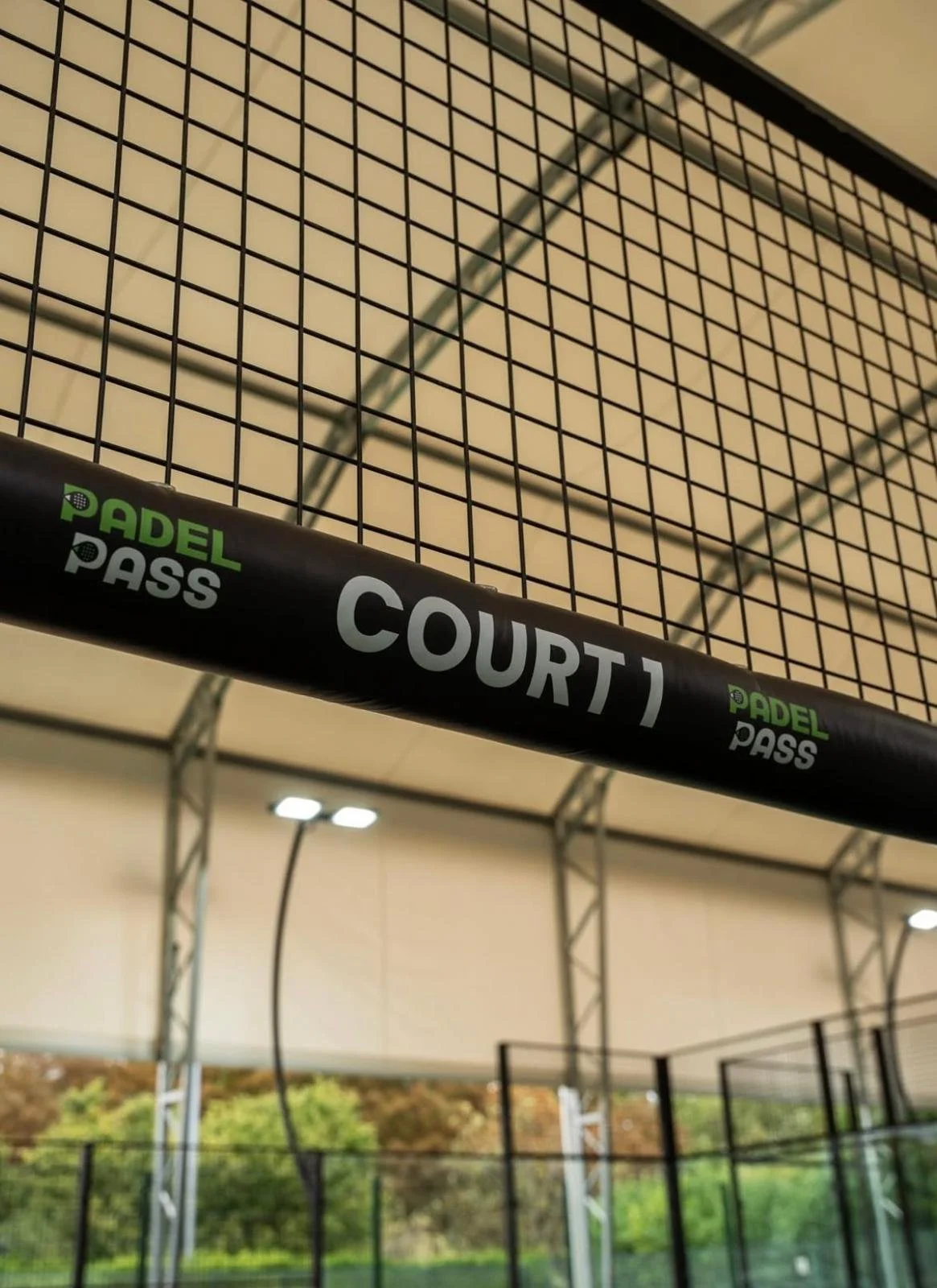 Padel court with personalized protective covers that say Padel Pass Court 2 underneath a canopy