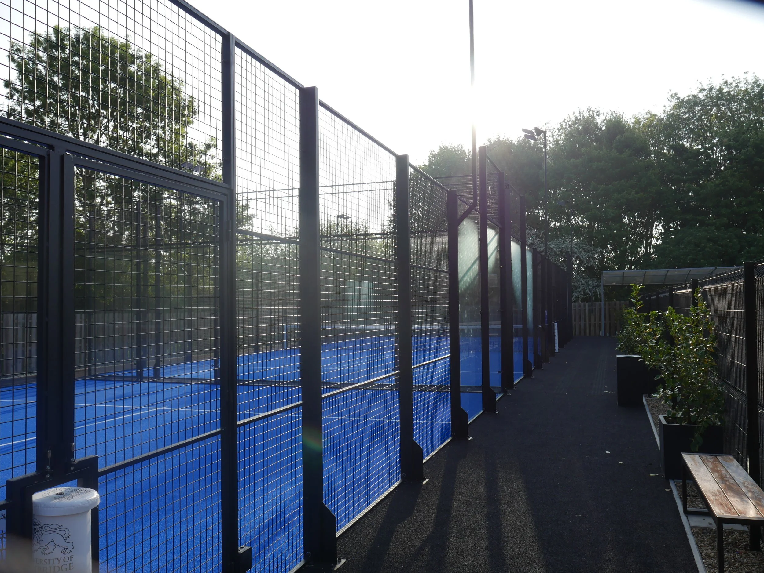 Outdoor Padel Court at the University of Cambridge with Blue turf and black pathway around the outside