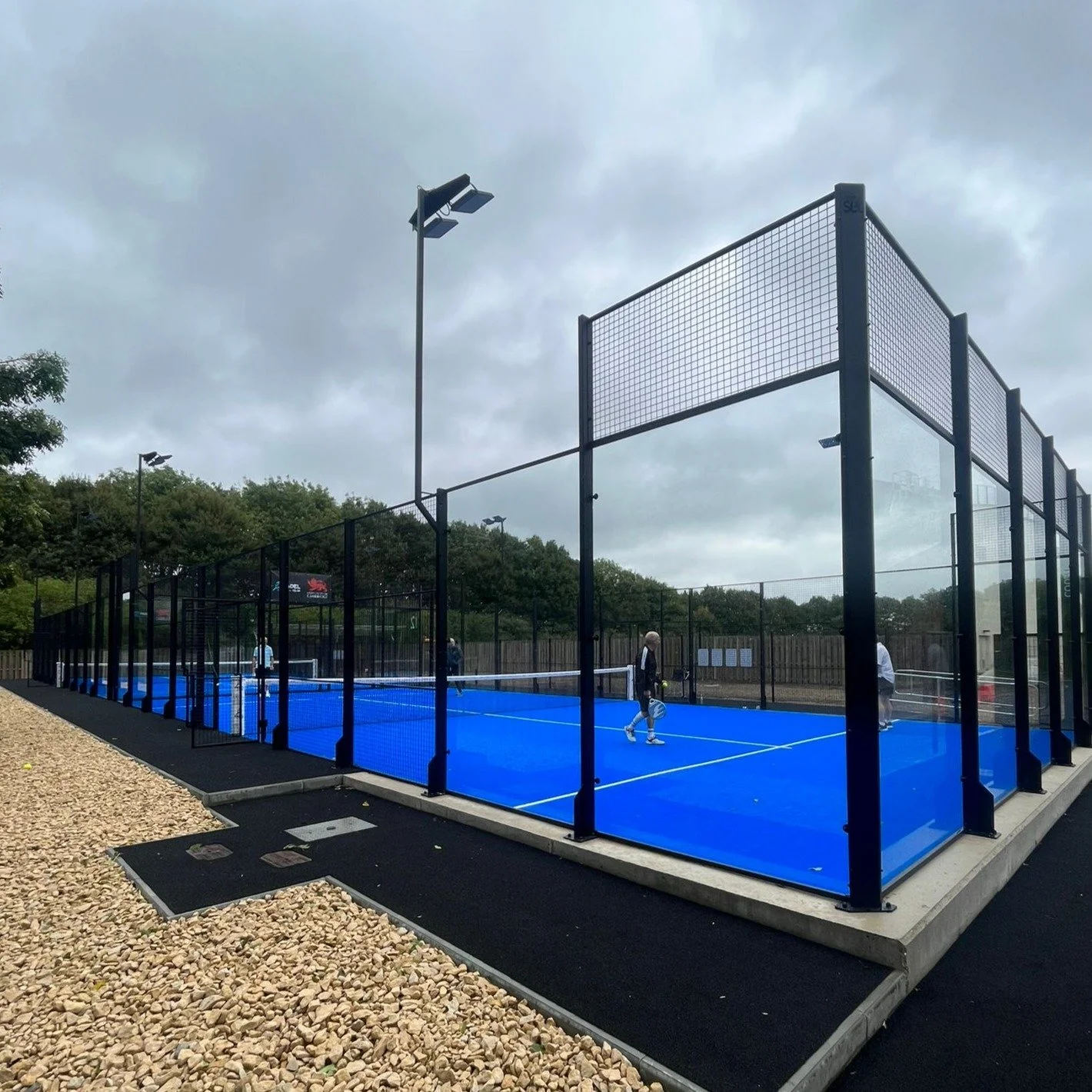A padel tennis court with blue turf and black perimeter turf. UKs Best Padel Courts