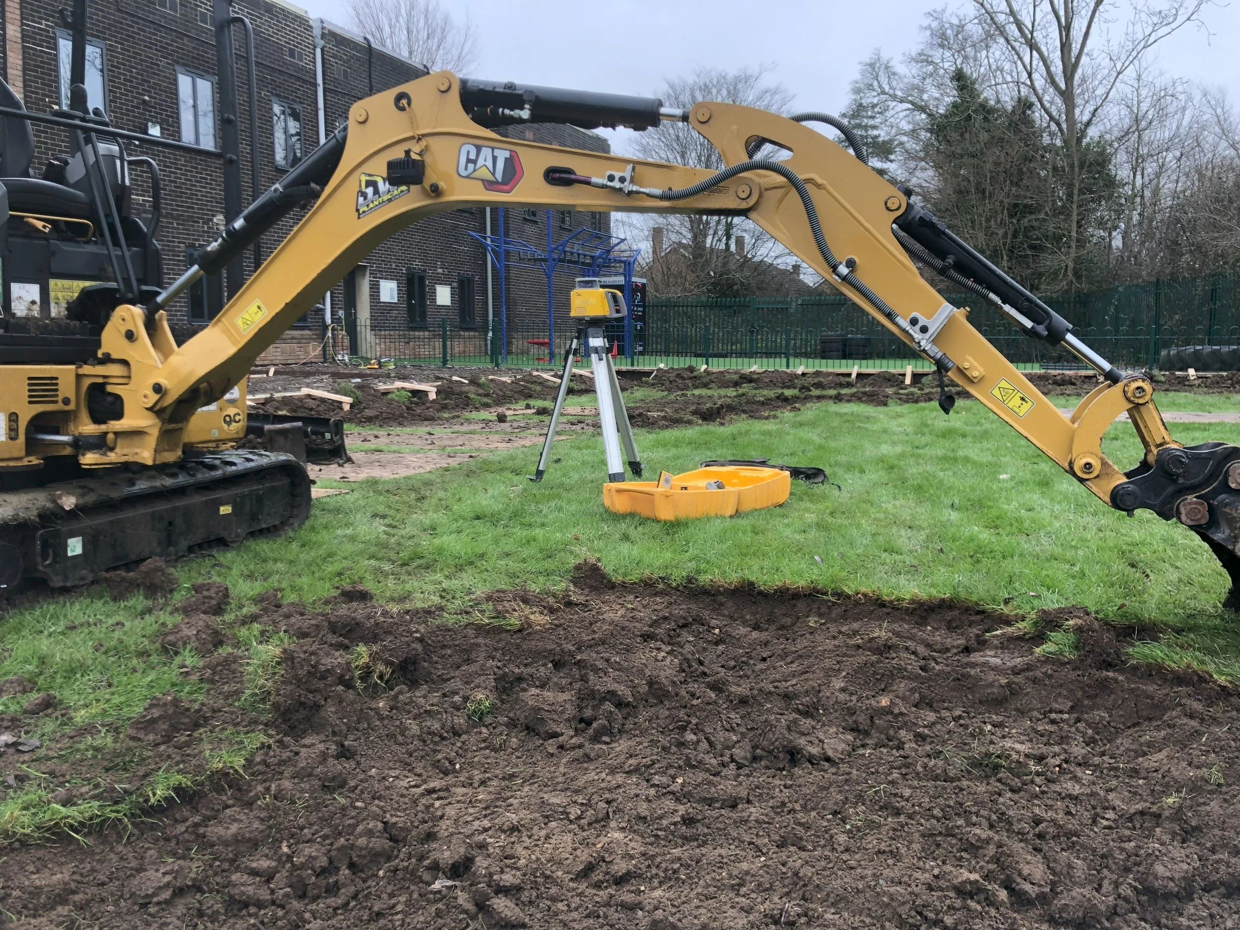 Construction site for Padel with a yellow CAT excavator digging into the ground in Essex Padel Court