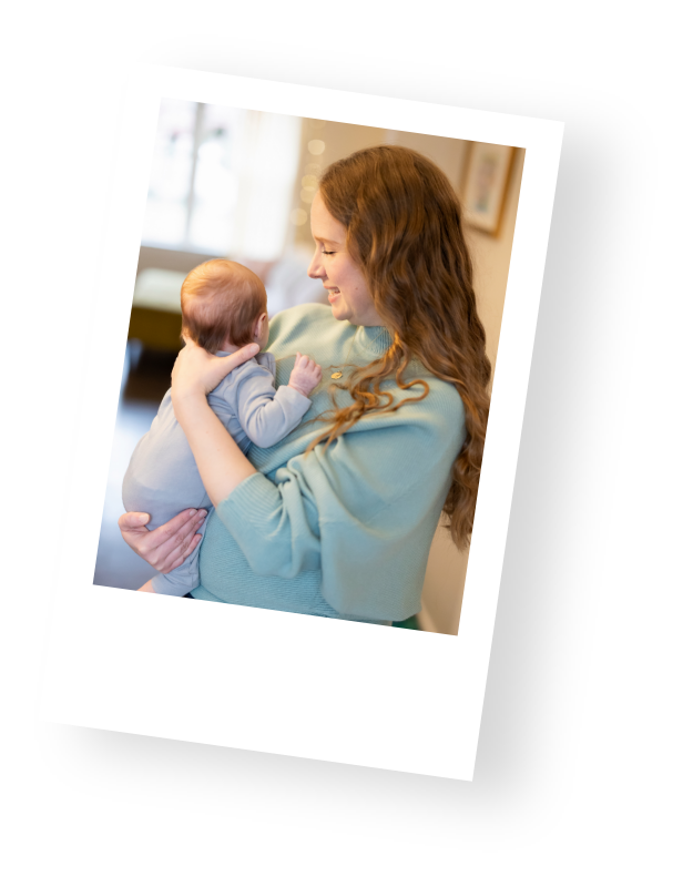 Mary Farrelly, a certified NICU doula and founder of The NICU Translator, holds a baby while providing preemie education to a family.