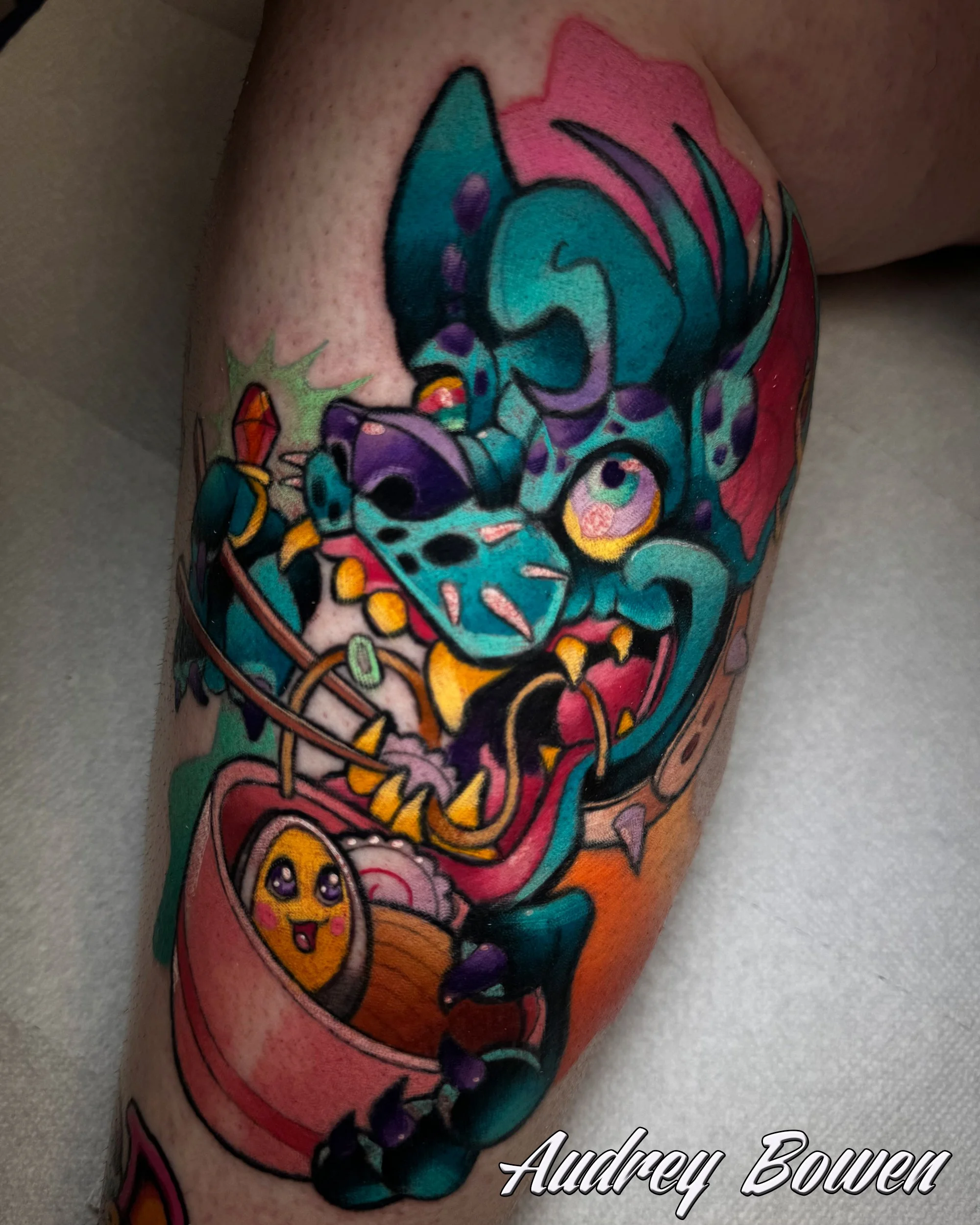 Colorful tattoo of a hyena with a rainbow-colored horn on a person's arm, with pink, purple, blue, yellow, and black ink accents. Tattoo by Audrey Bowen, Karmic Tattoo, Clearwater Florida
