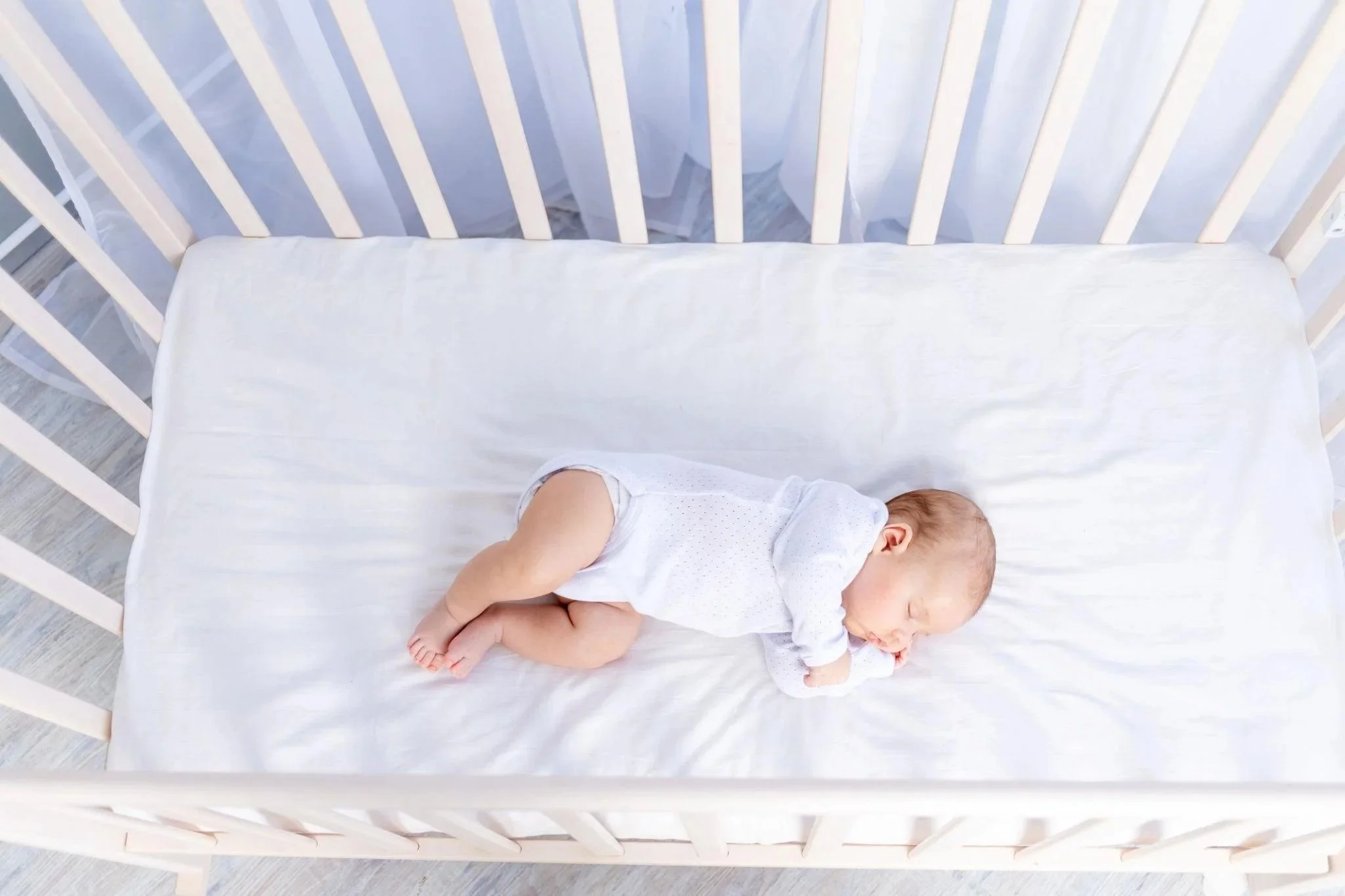 Baby sleeping alone in cot