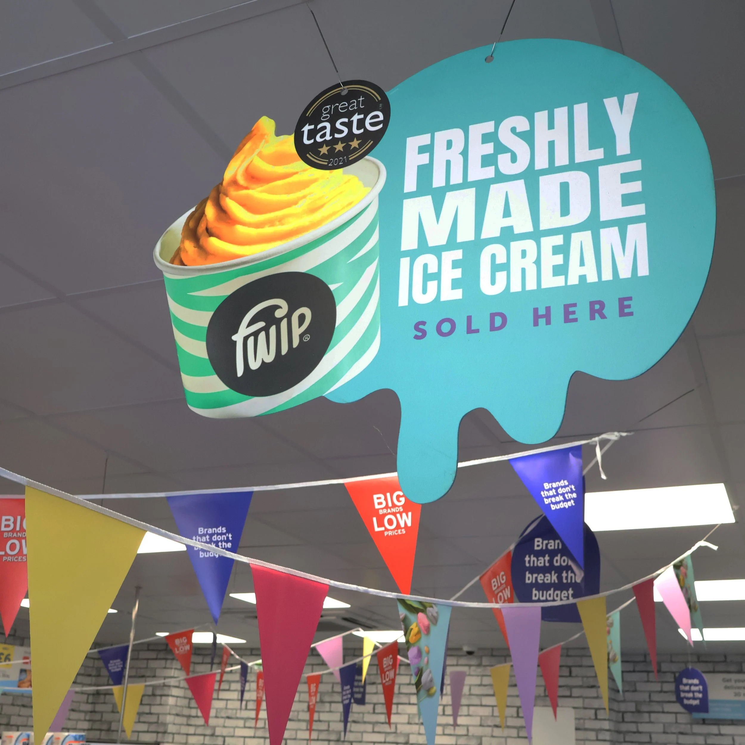 Sign showcasing freshly made ice cream from Twip, with a picture of orange ice cream in a bowl, and a bubble shape with text highlighting its quality.